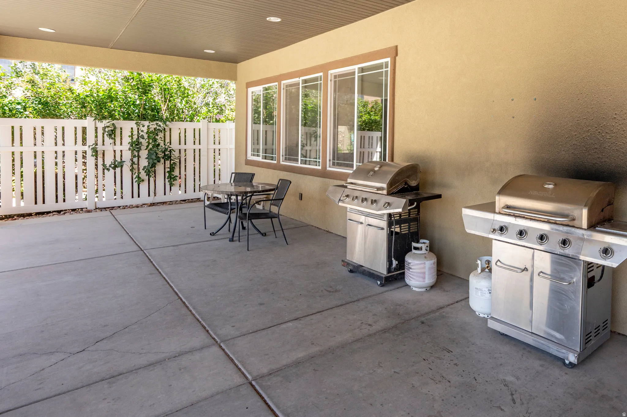 Covered patio featuring a concrete slab, recessed lighting, and a white picket fence perimeter