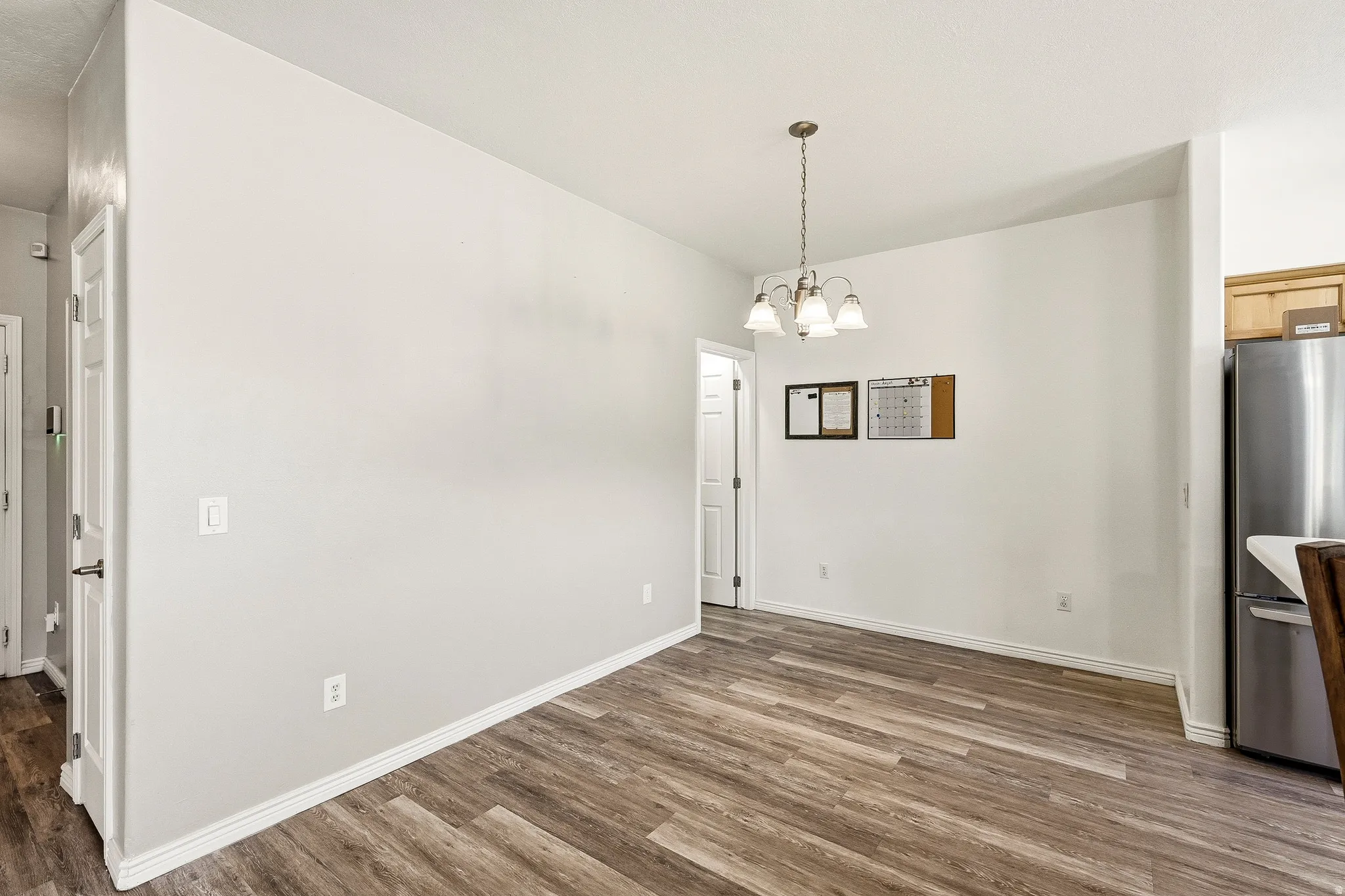 Open dining area featuring wood-finish flooring and a contemporary chandelier