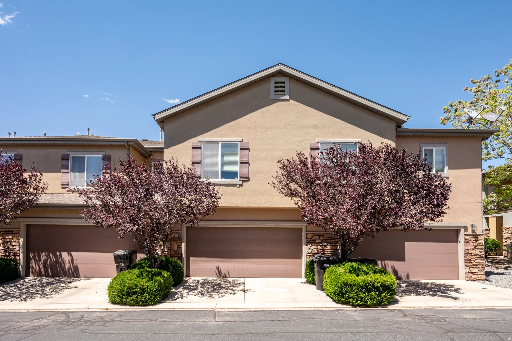 Multi-unit residential exterior featuring stucco siding and a pitched roofline