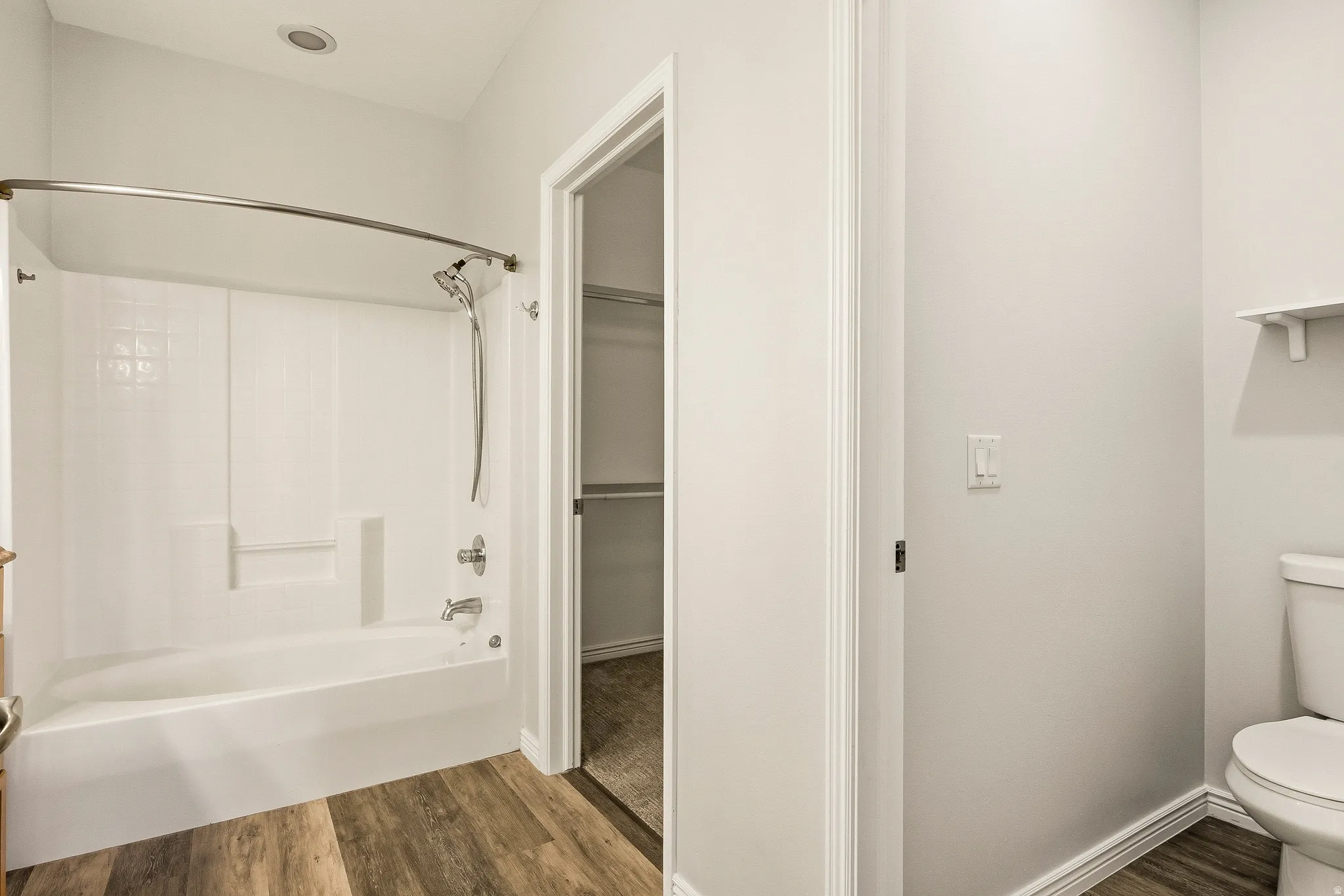 Bathroom featuring a white tub and shower combination with chrome fixtures and a curved shower rod