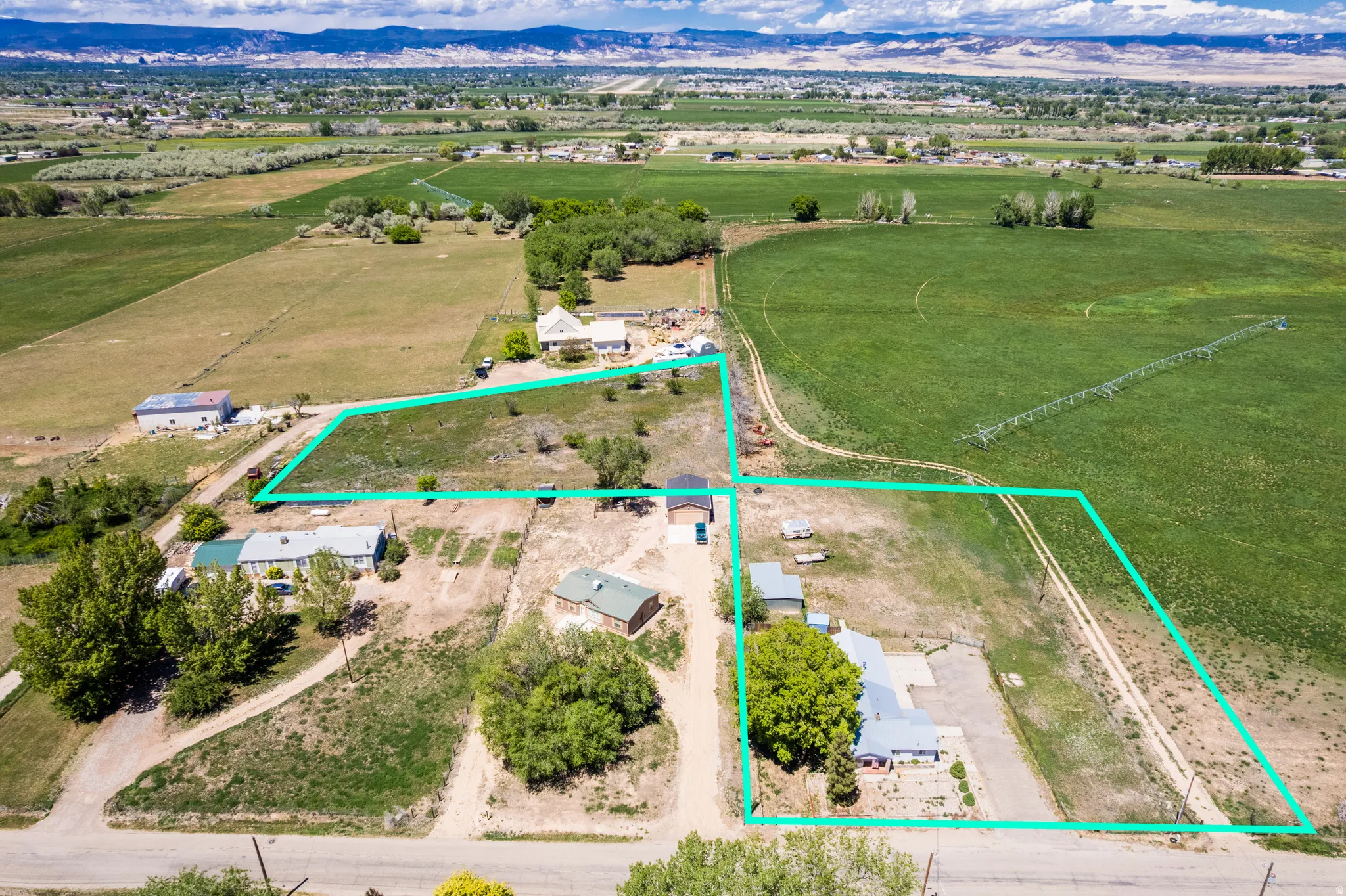 Aerial perspective showcasing multiple parcels outlined in green, surrounded by expansive green agricultural fields