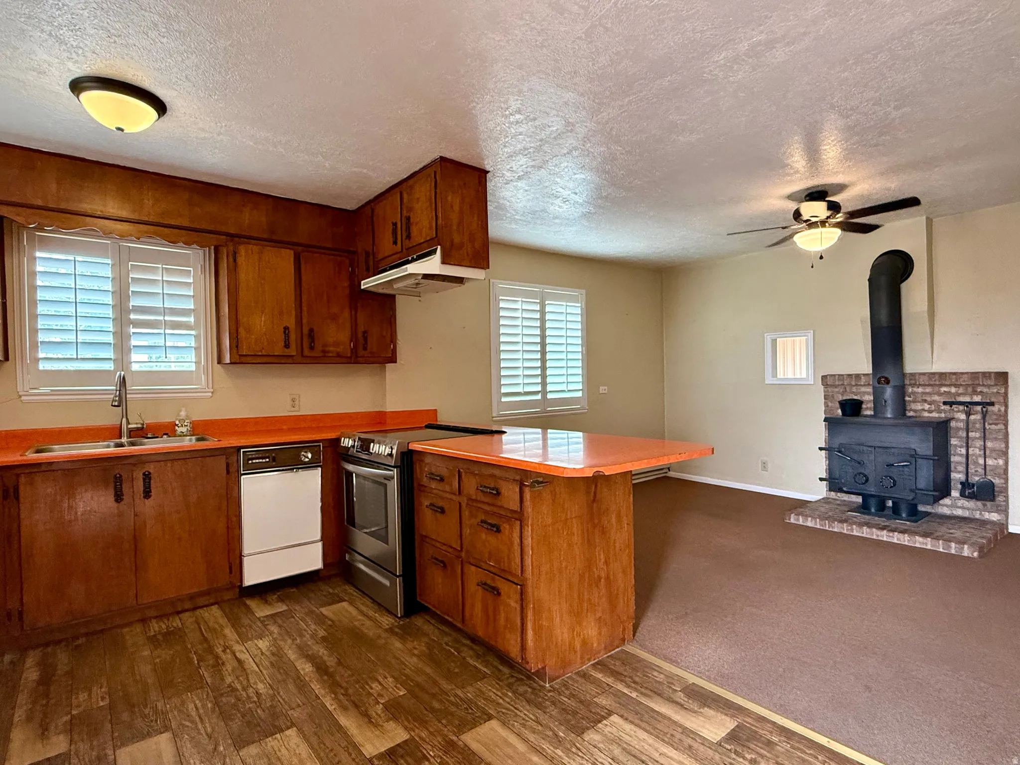 Kitchen featuring wood-finish flooring, wood cabinetry, and orange countertops