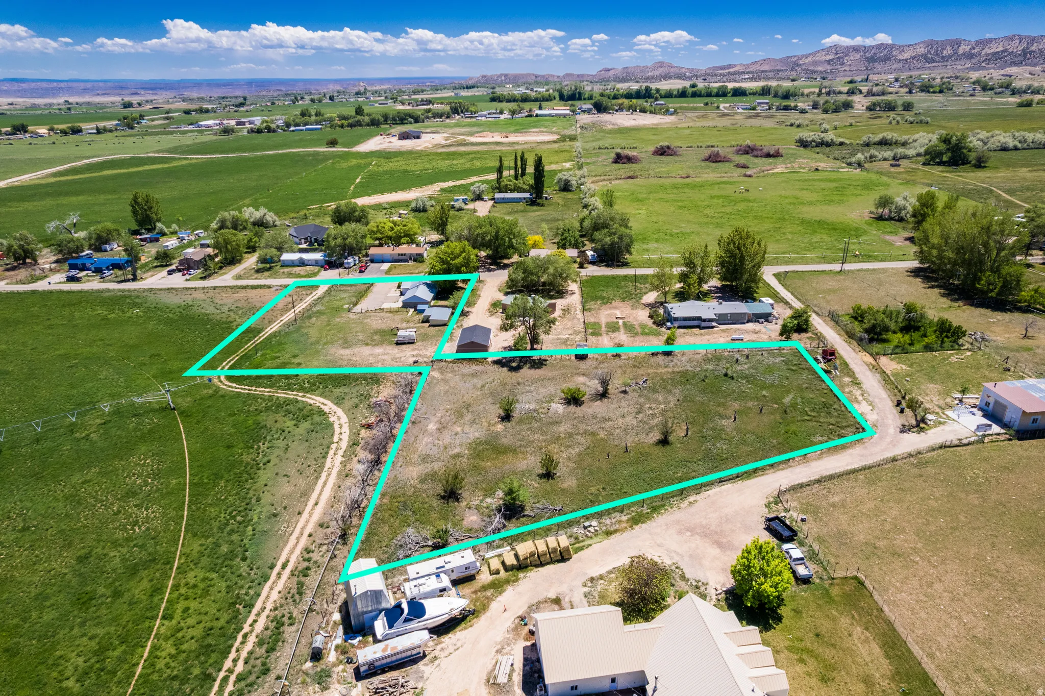 Expansive rural parcels outlined in green, featuring multiple structures and surrounding agricultural fields