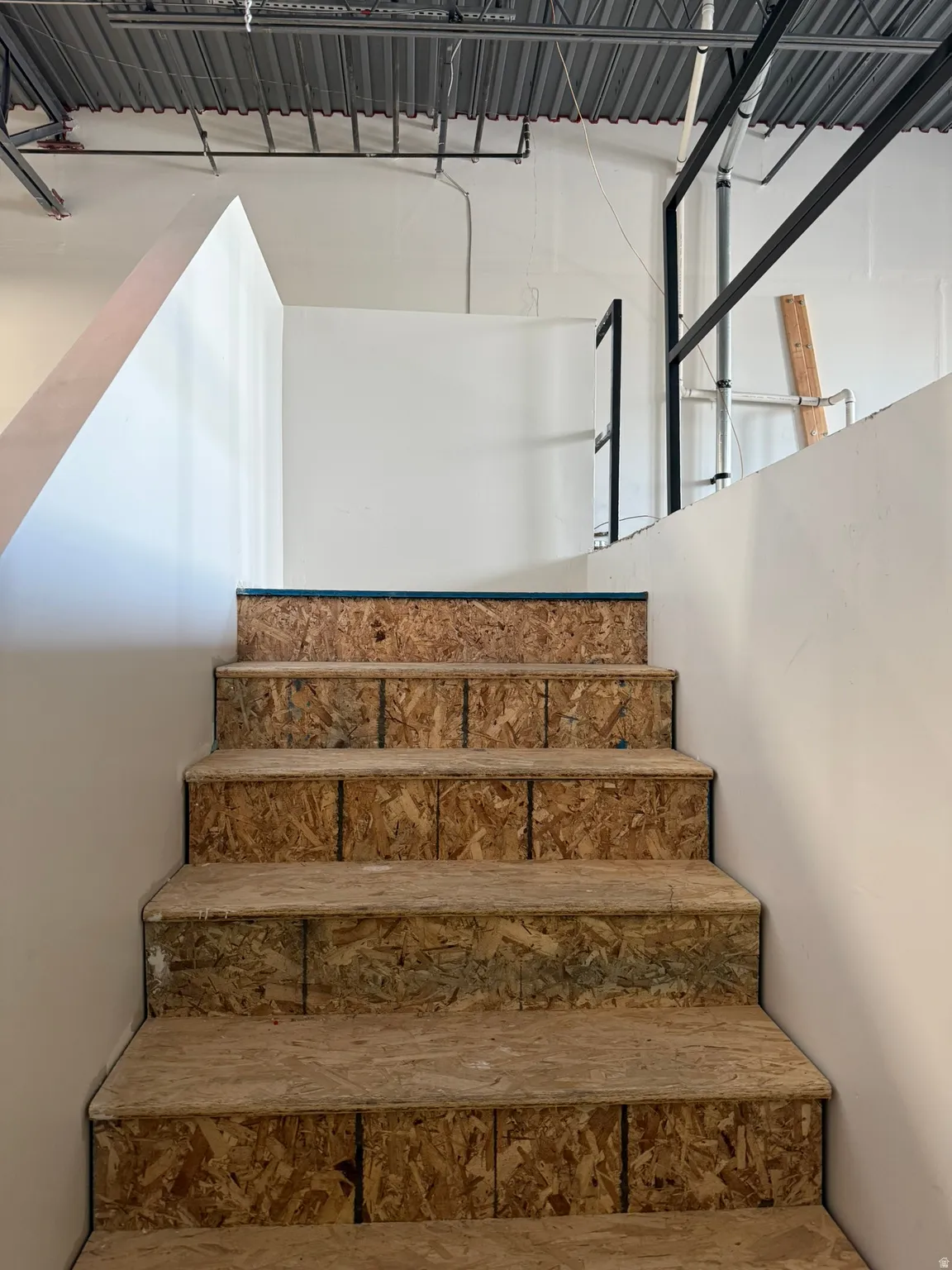 Staircase featuring exposed oriented strand board treads and risers