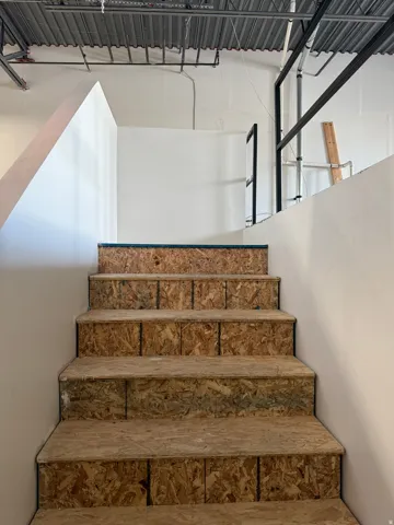 Staircase featuring exposed oriented strand board treads and risers