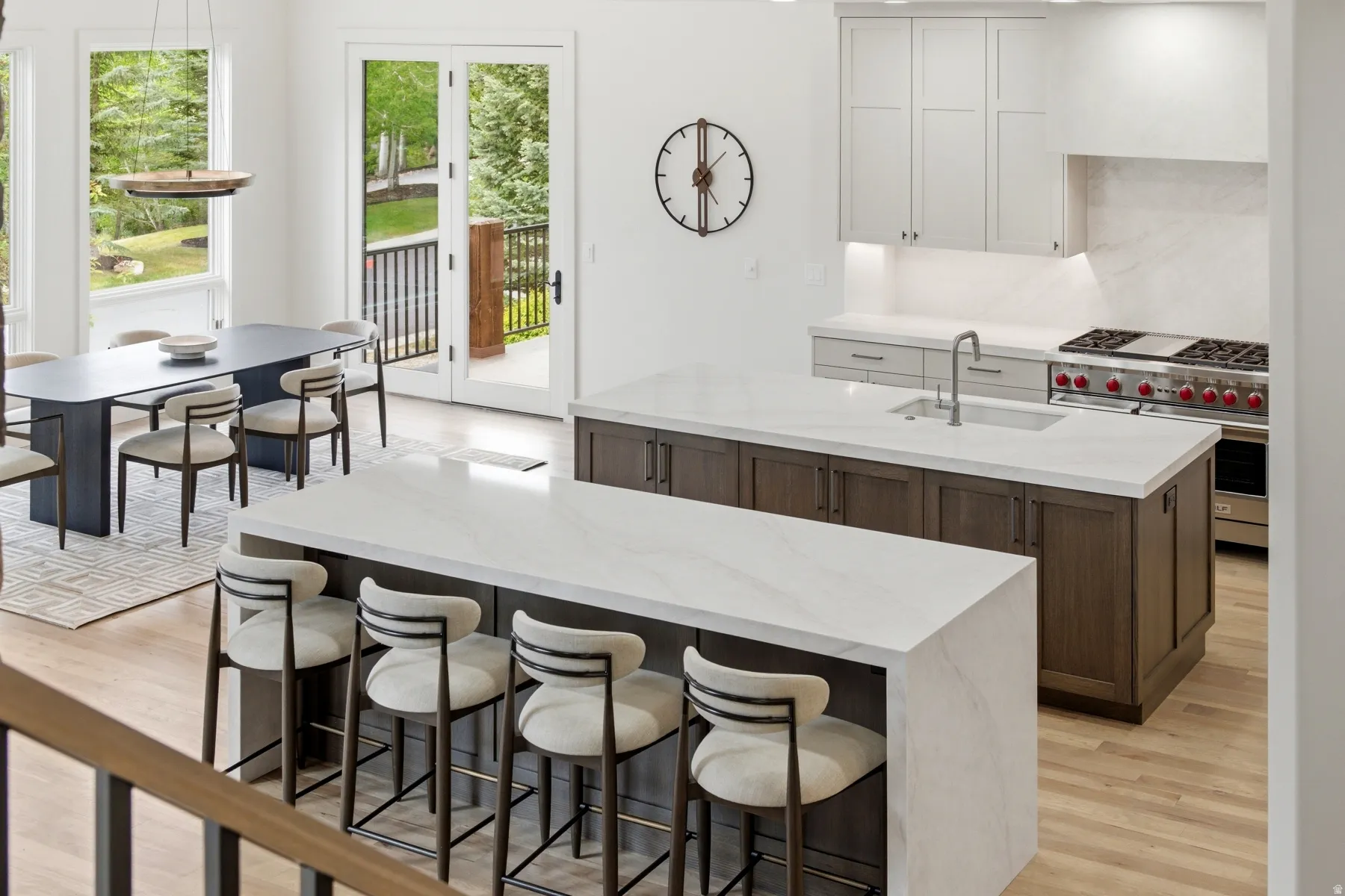 Spacious kitchen featuring two islands with waterfall countertops, and dual islands