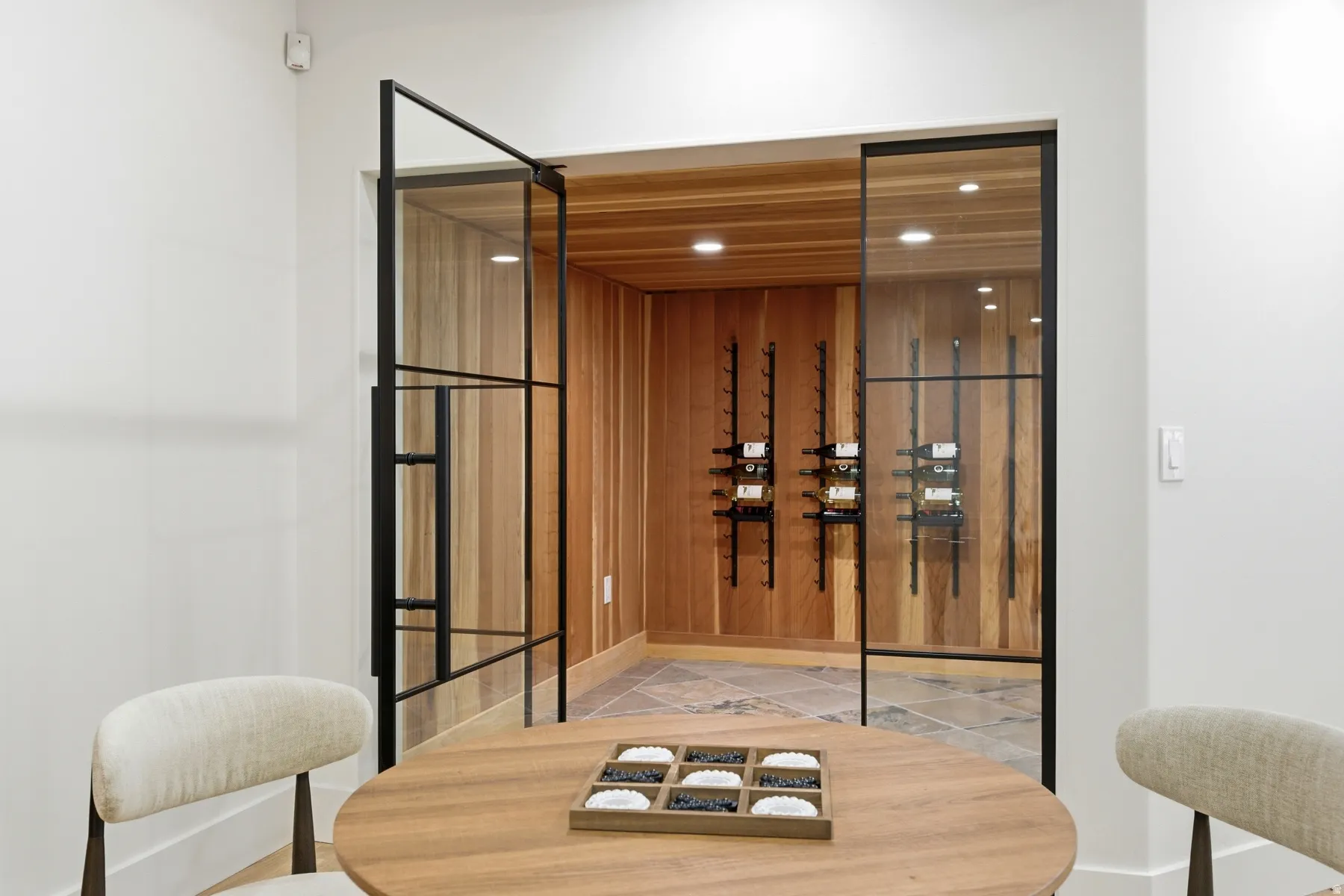 Custom wine cellar featuring wood paneling and stone tile flooring