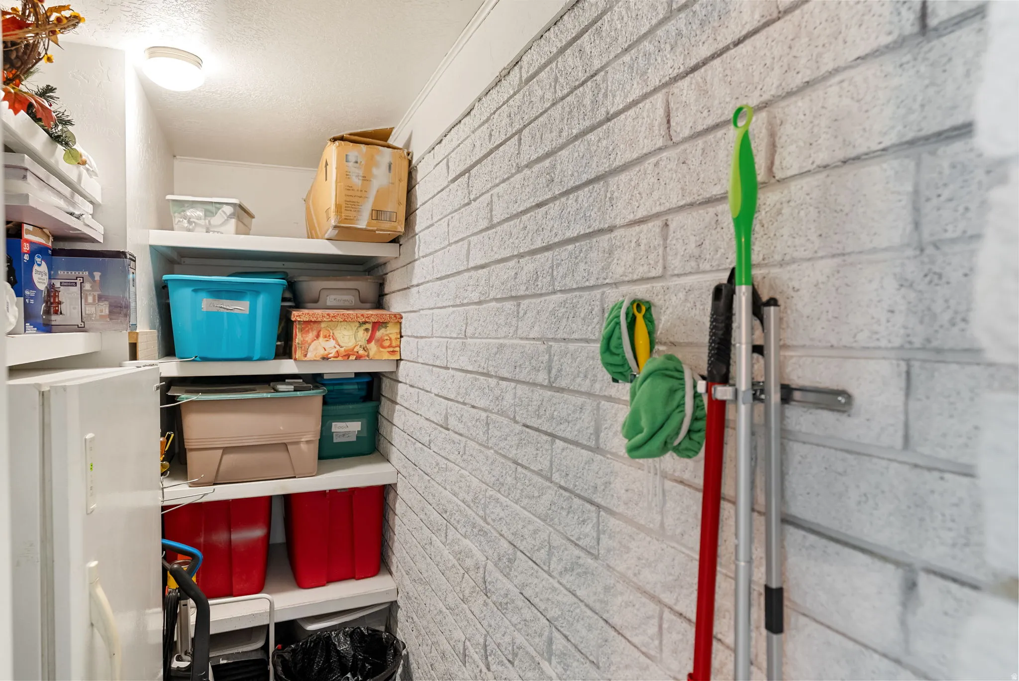 Dedicated storage area featuring white brick-patterned walls
