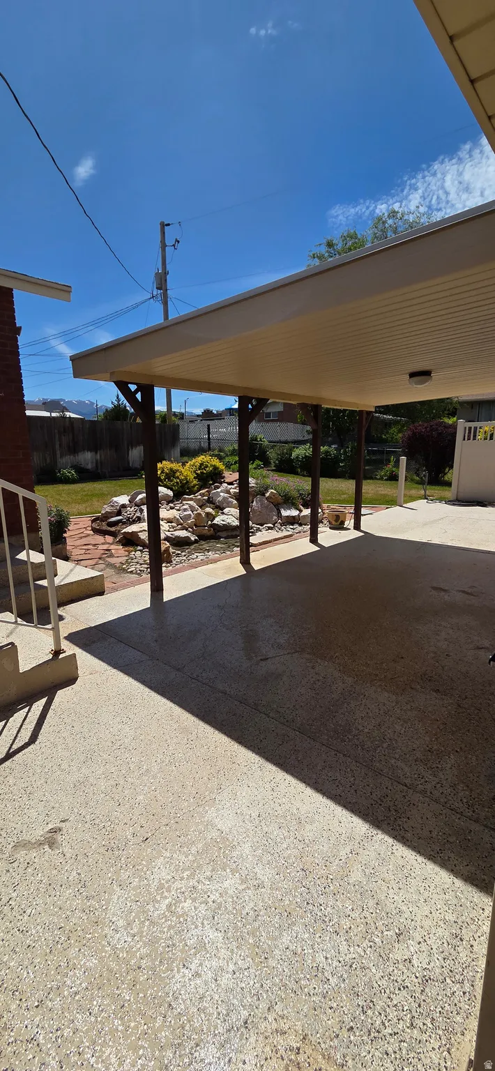 Covered patio featuring a concrete surface and supported by dark wood posts