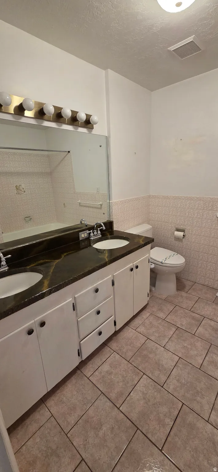 Double vanity with dual undermount sinks and a dark, veined countertop