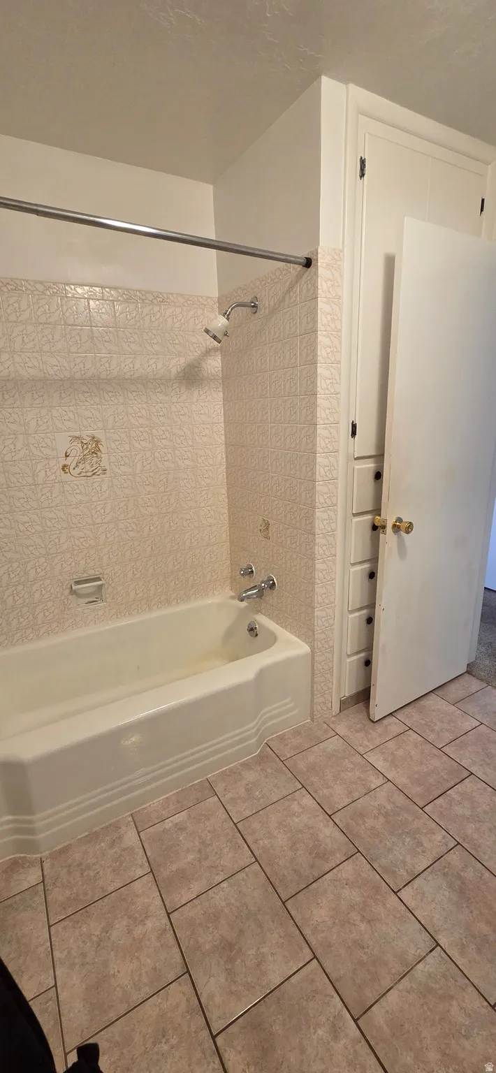 Bathroom featuring a built-in tub with a shower fixture