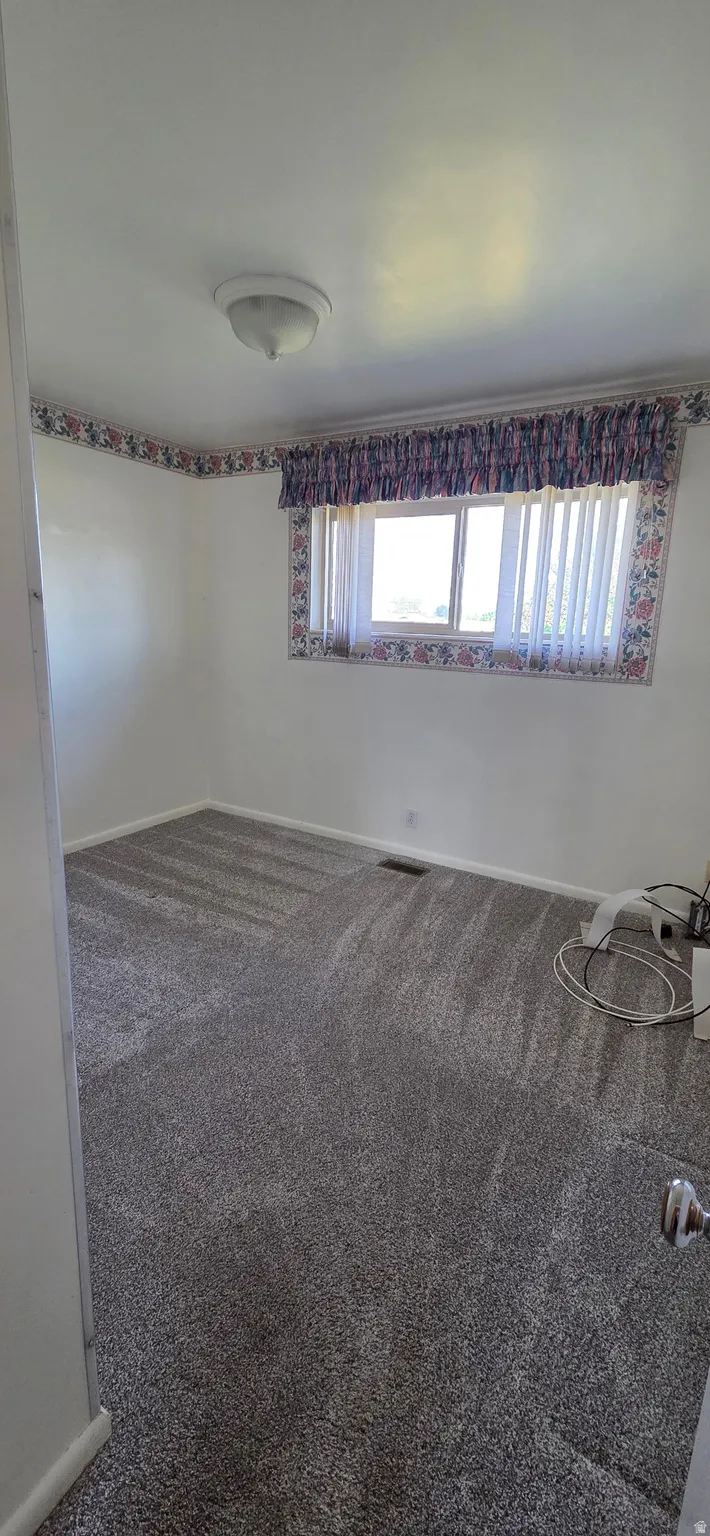 Room featuring neutral wall finishes and grey textured carpeting