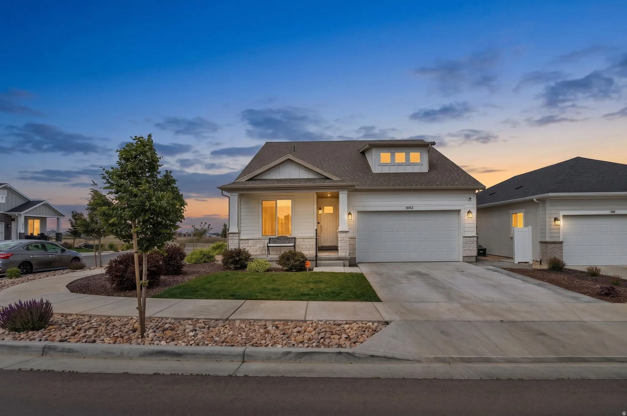 Contemporary single-story residence featuring white siding and stone accents