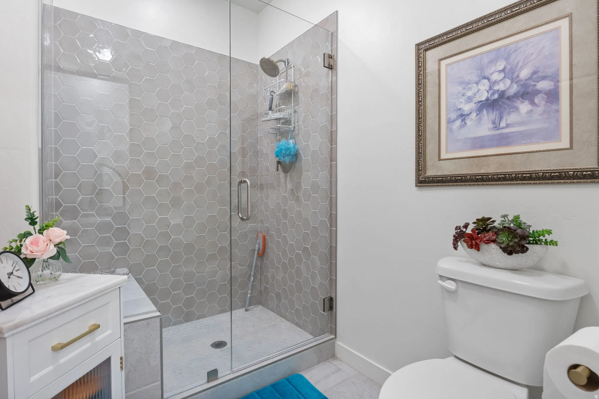 Glass-enclosed shower featuring hexagonal tile surround and a built-in bench