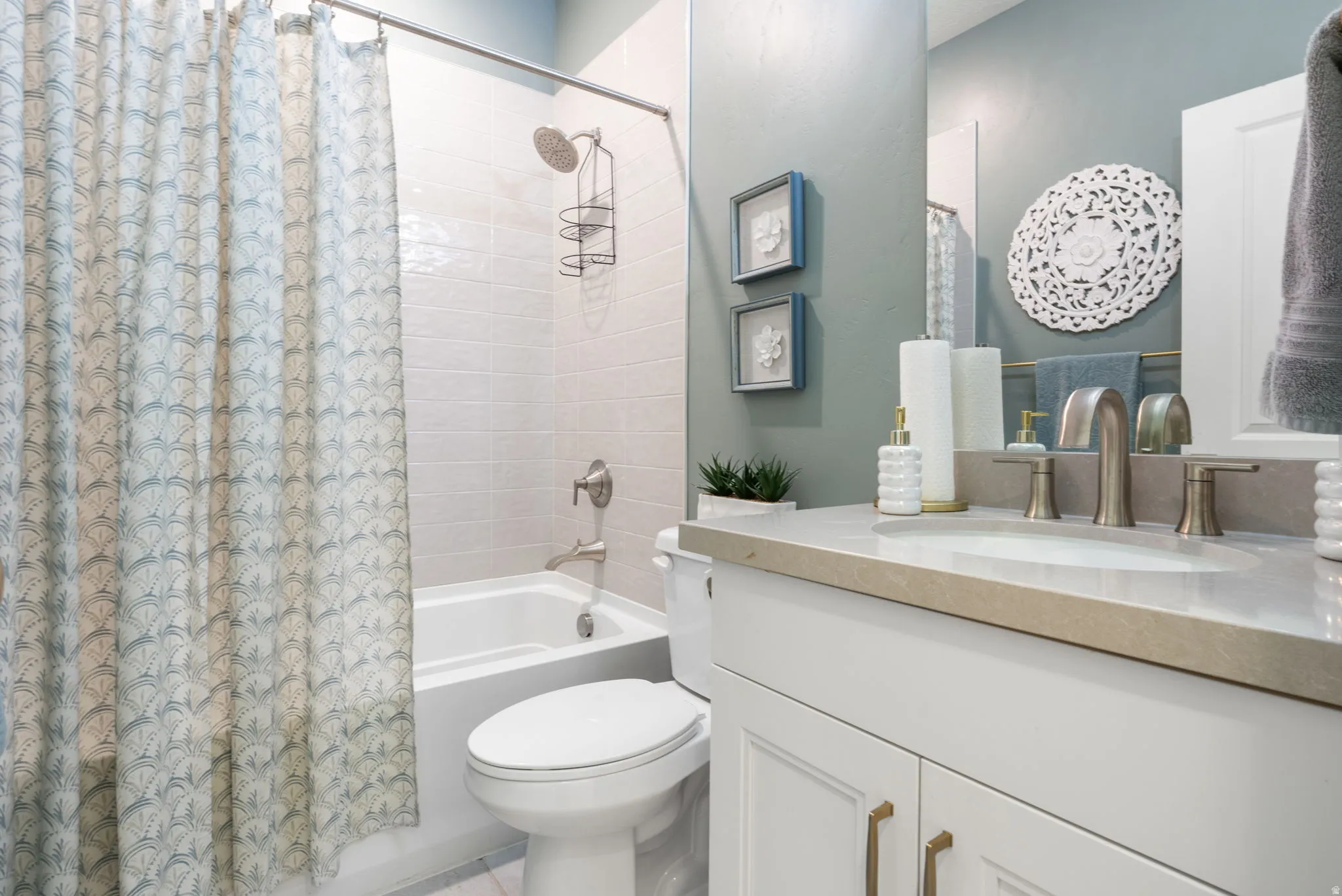 Bathroom featuring a single vanity with a stone countertop, an undermount sink, and brushed nickel fixtures