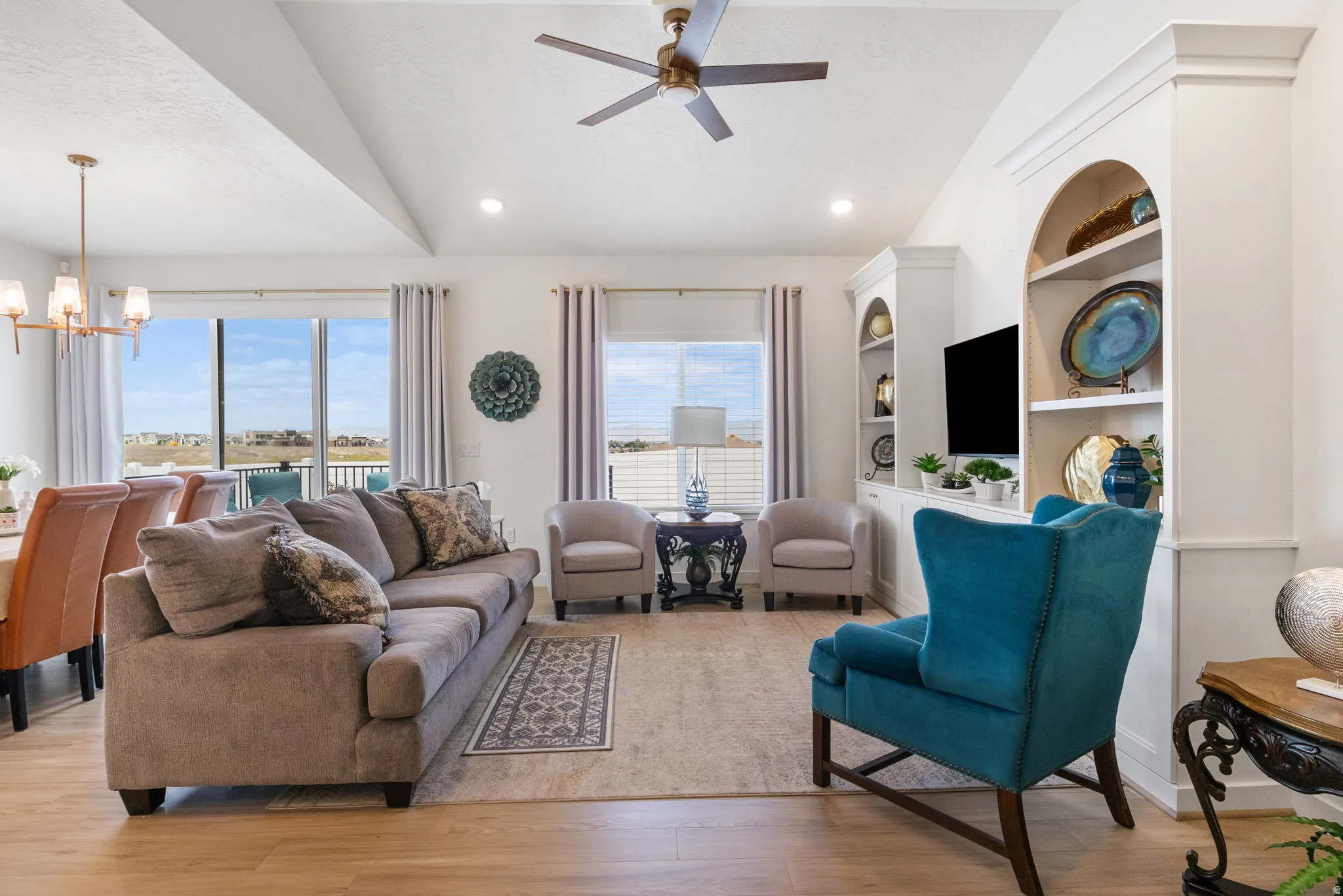 Vaulted ceiling living area featuring wood-finish flooring