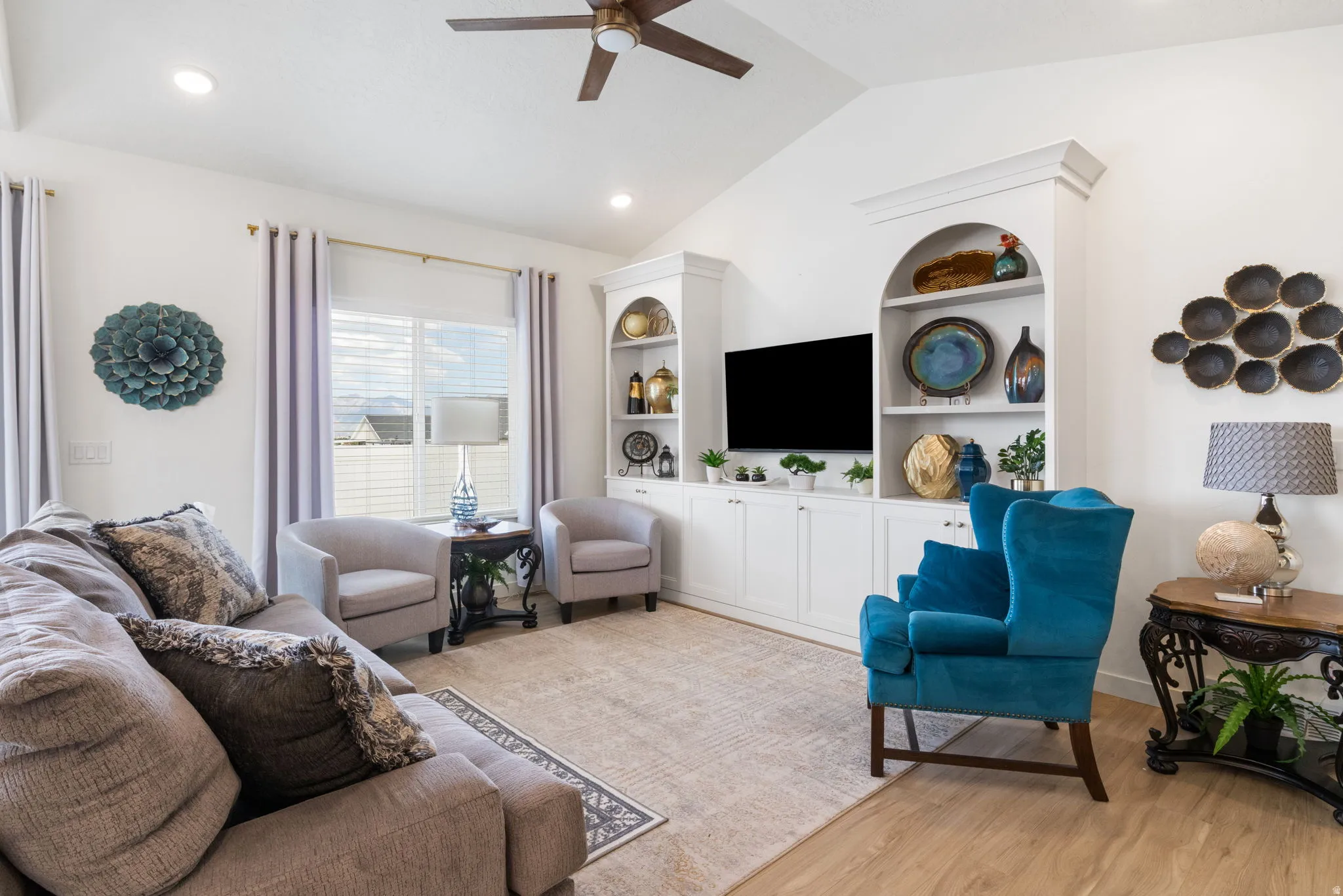 Vaulted ceilings enhance this living area featuring light wood-finish flooring