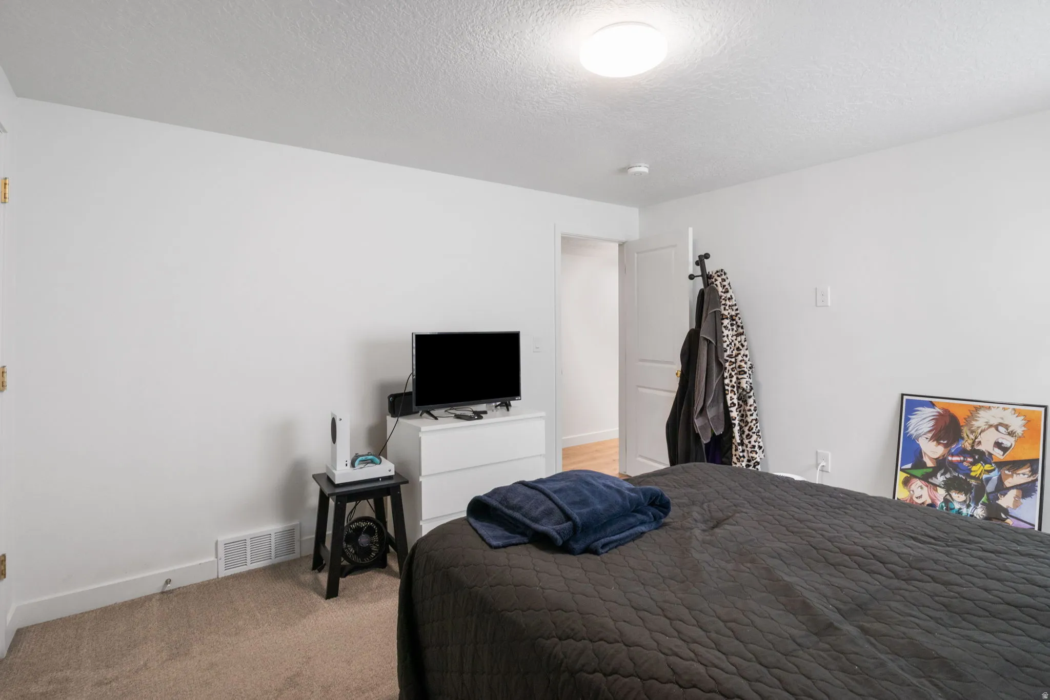 Light-filled interior space featuring neutral wall paint, carpet flooring, a flush-mount ceiling light, white baseboards, and a white interior door