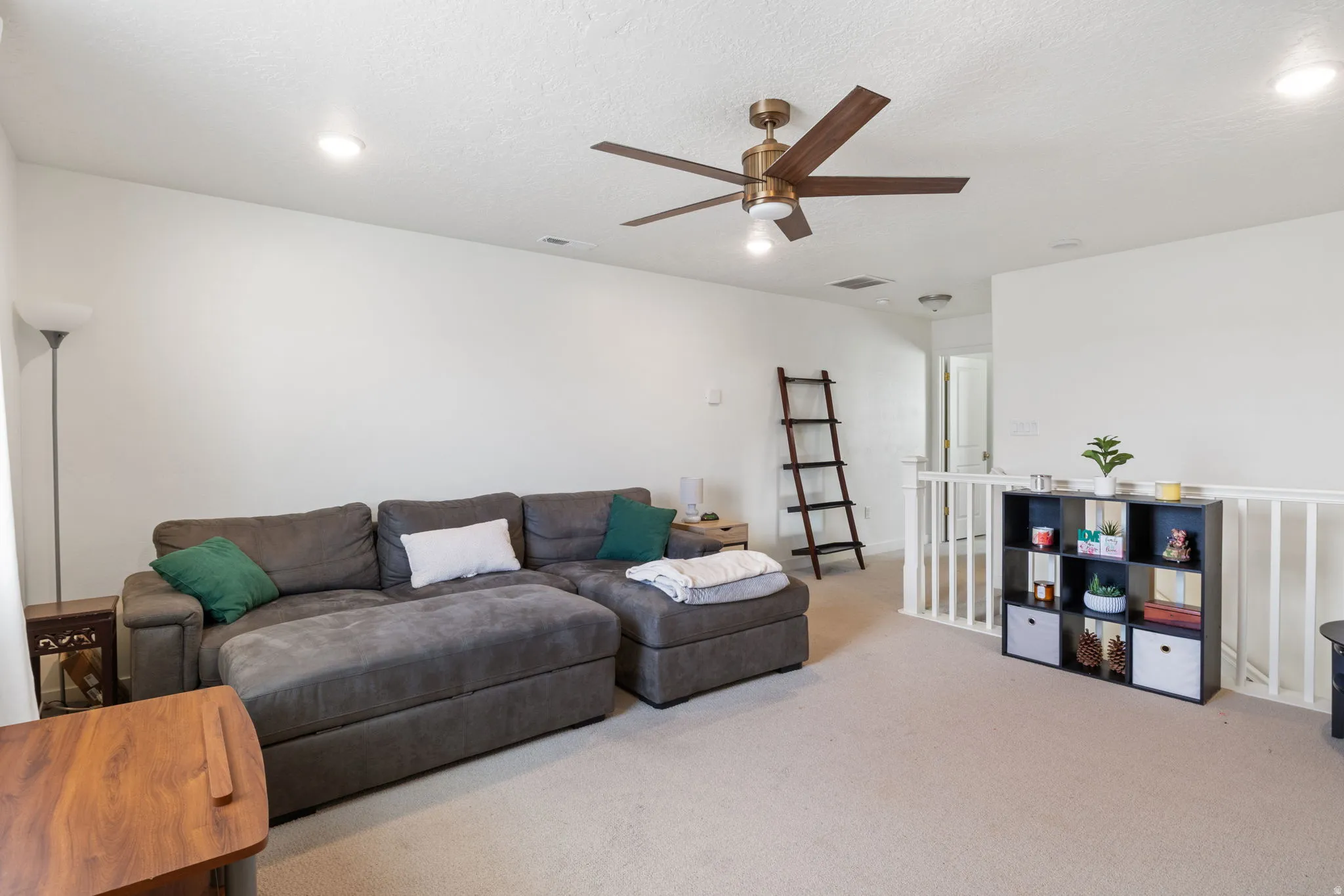 Carpeted upper-level living area with recessed lighting and a ceiling fan