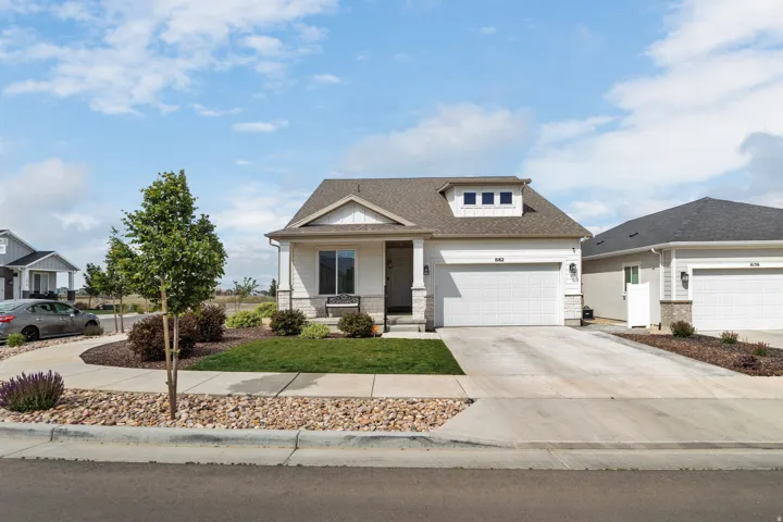 Single-story residence featuring a two-car garage, dormer window, and stone accents