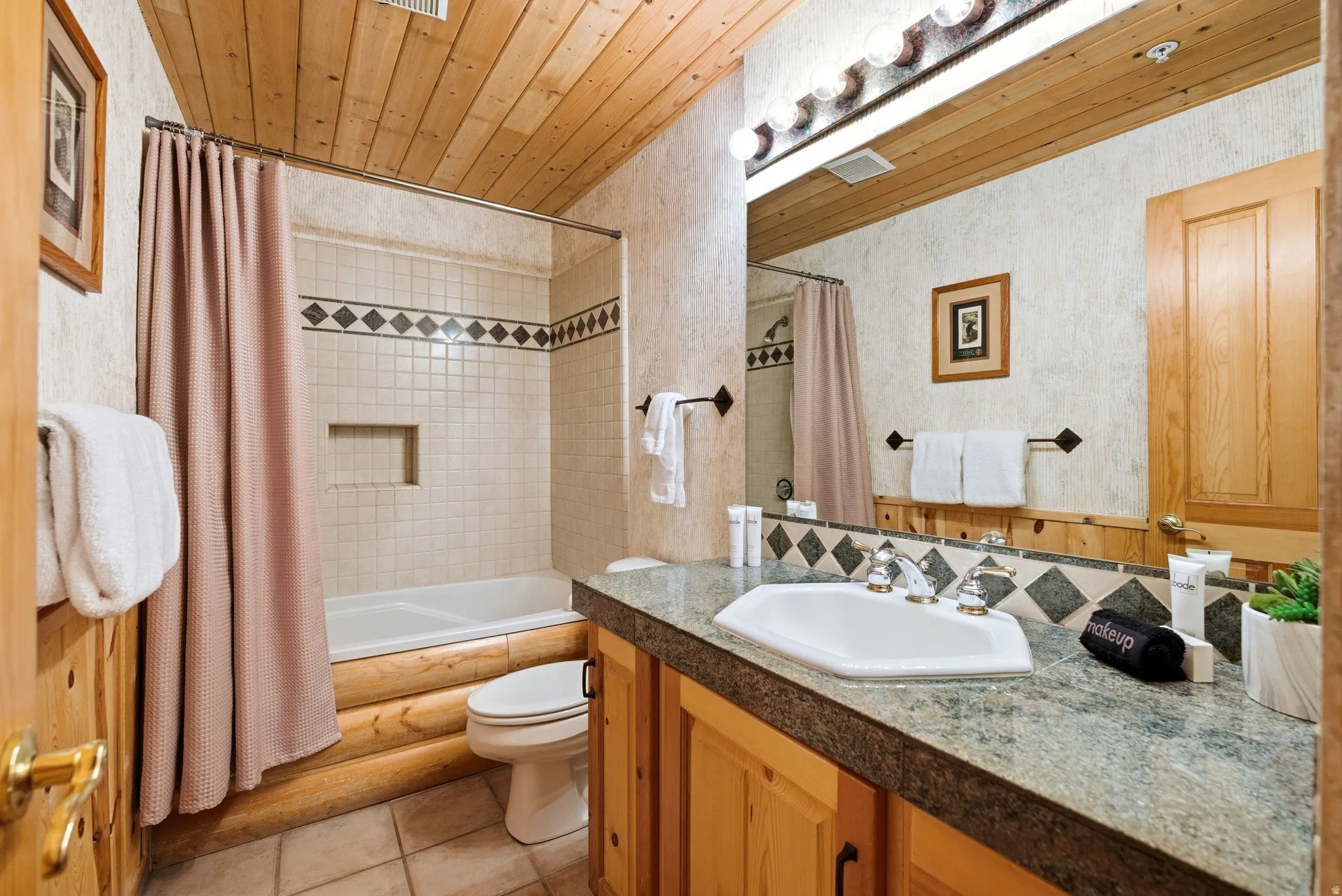 Bathroom featuring a wood-finish plank ceiling, tile flooring, and a vanity with a solid surface countertop
