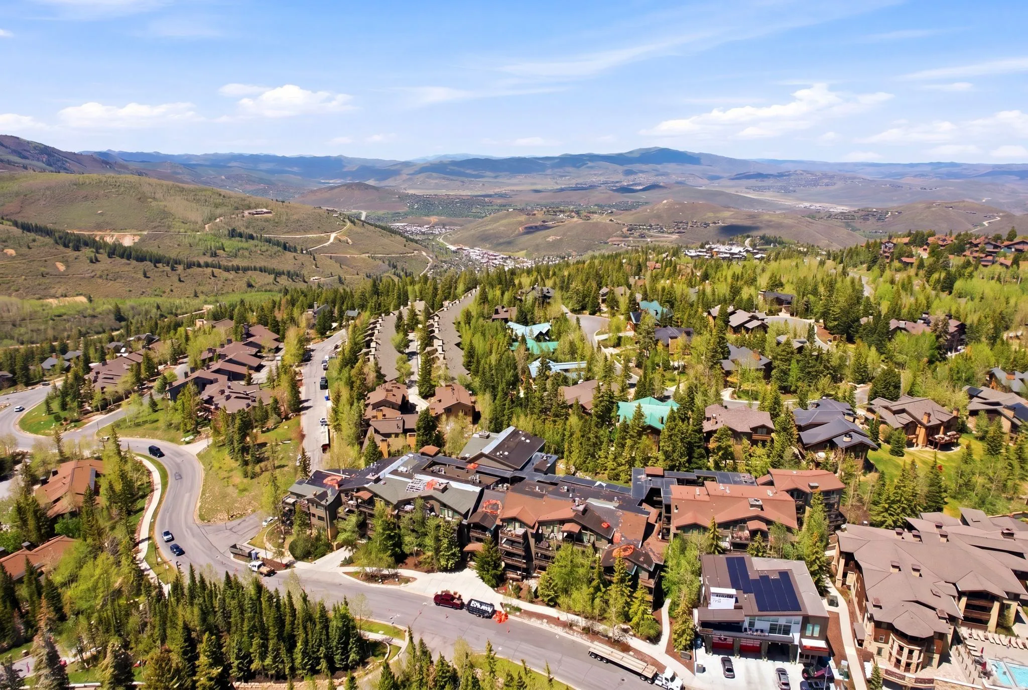 Expansive mountain landscape featuring numerous properties nestled among evergreen and deciduous trees