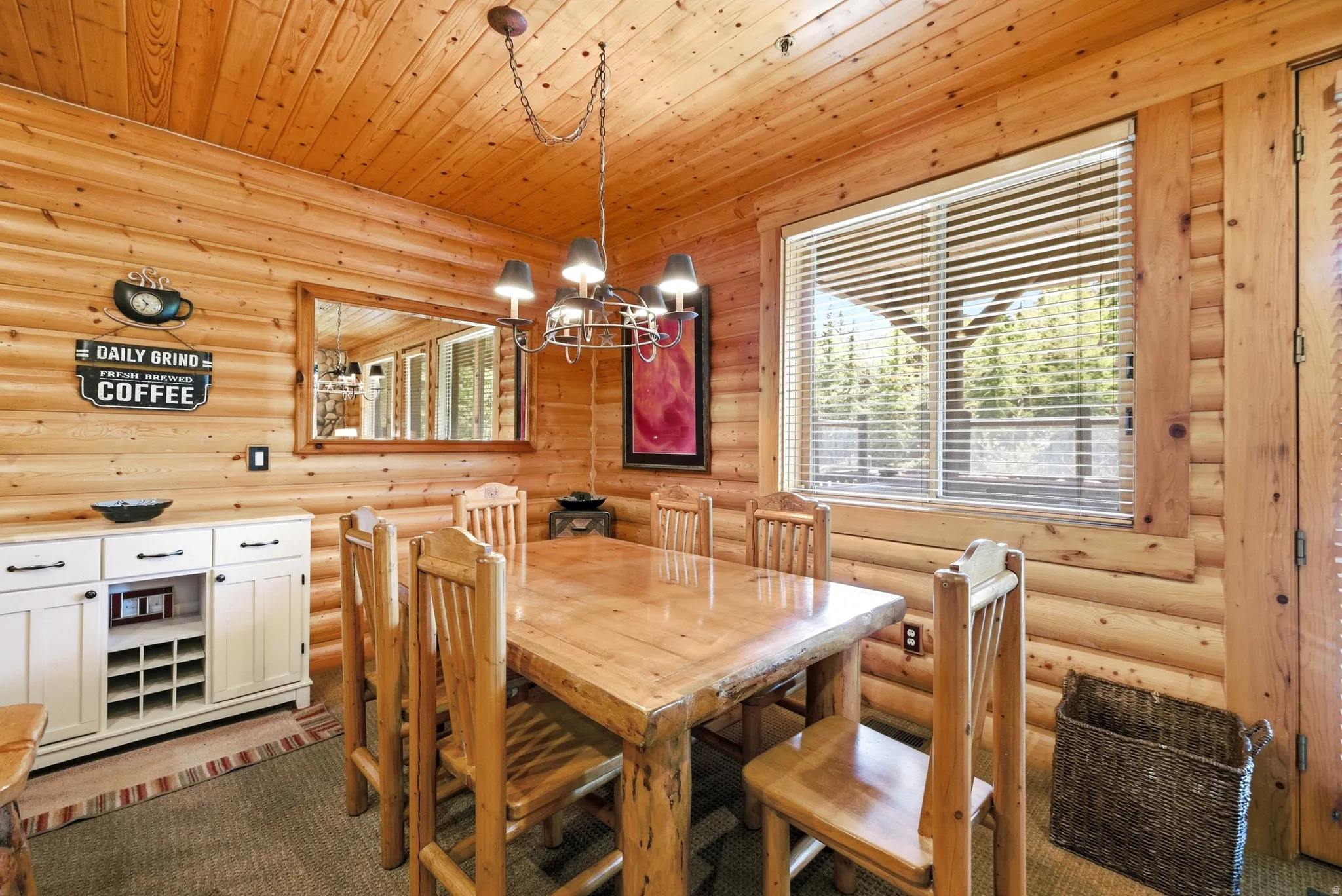 Dining area featuring natural wood log walls and ceiling