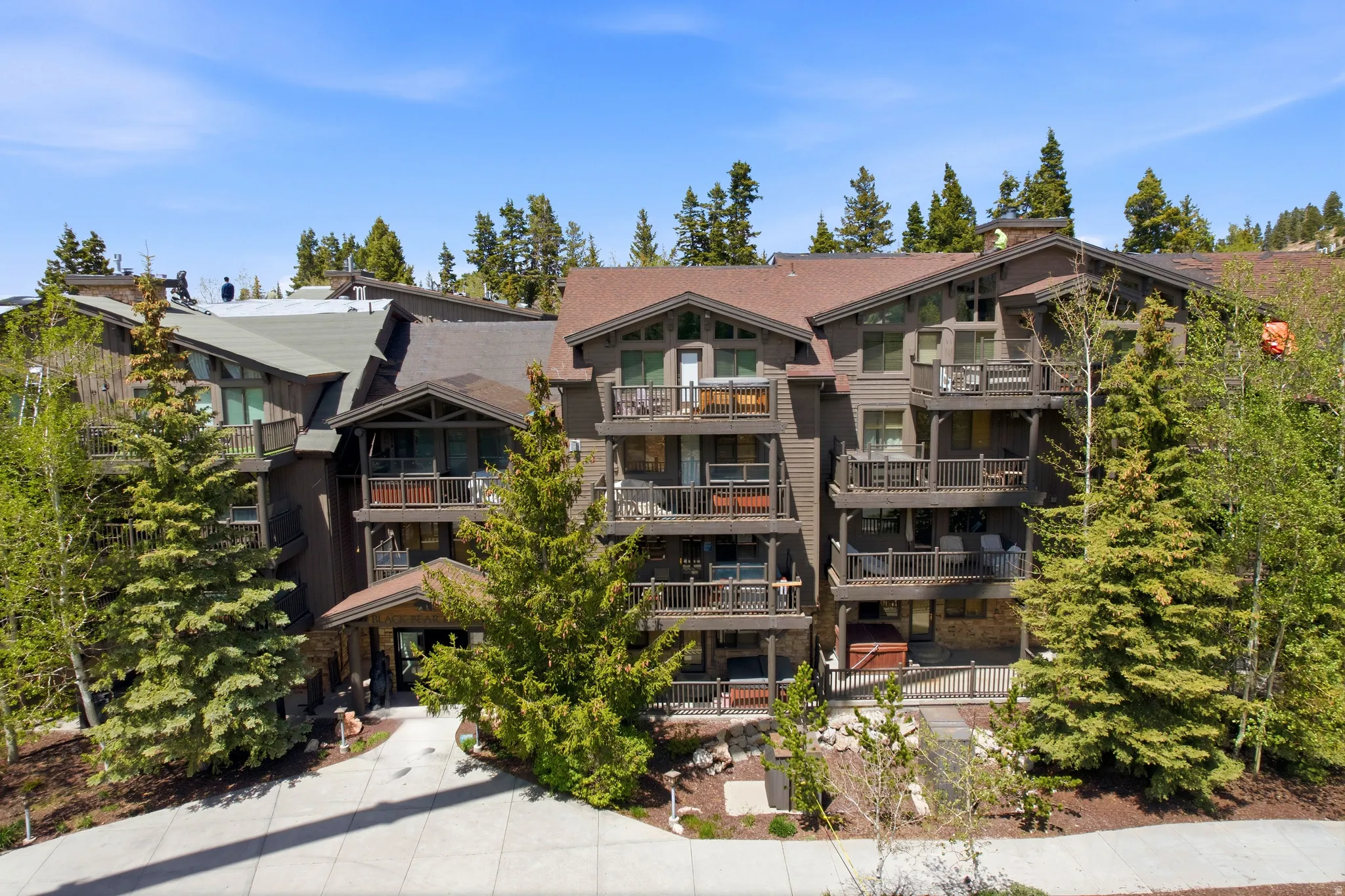 Multi-story complex featuring a blend of wood siding and stone accents