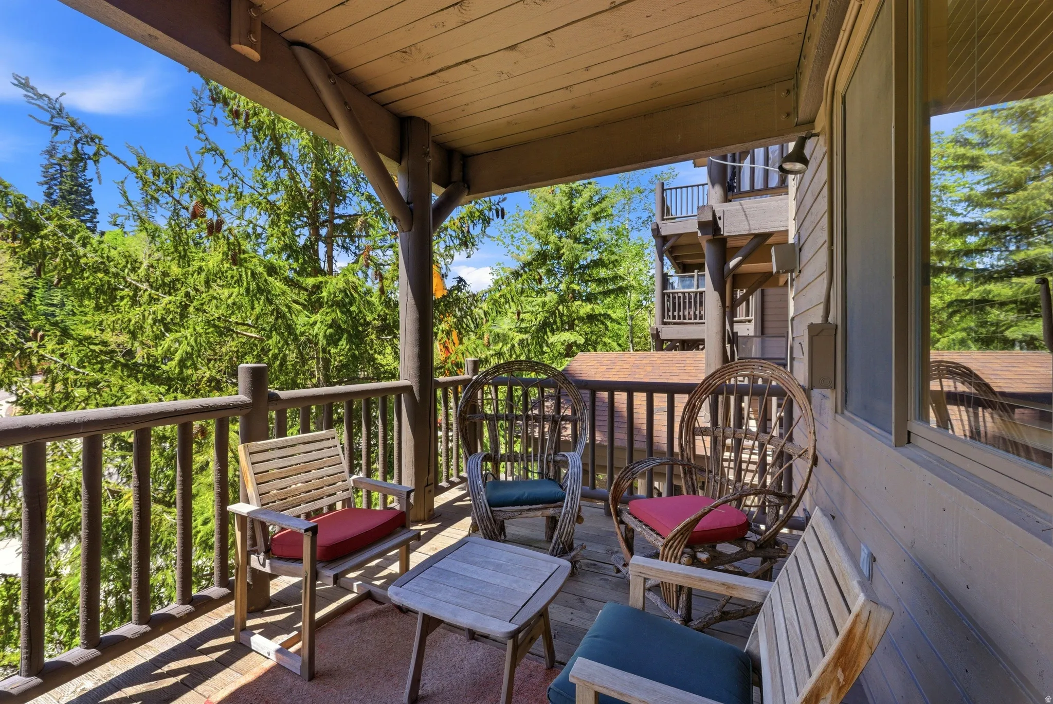 Covered outdoor balcony featuring a wood-plank ceiling, wood railing, and plank flooring