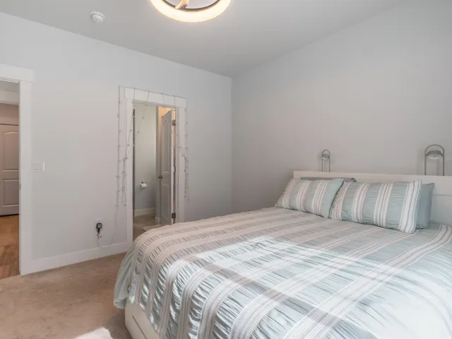 Neutral tone wall paint with white trim, soft beige carpet, and a modern ceiling fixture