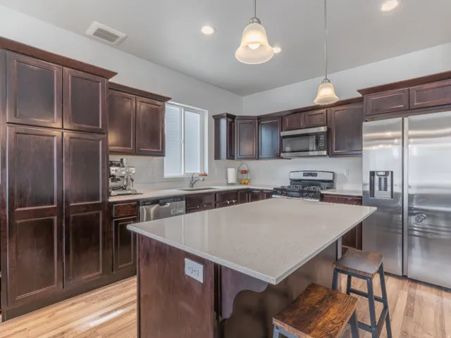 Kitchen featuring wood-finish flooring, dark wood cabinetry, and a light-toned countertop island