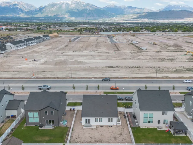 Aerial perspective showcasing residential properties with mountain backdrop and undeveloped land