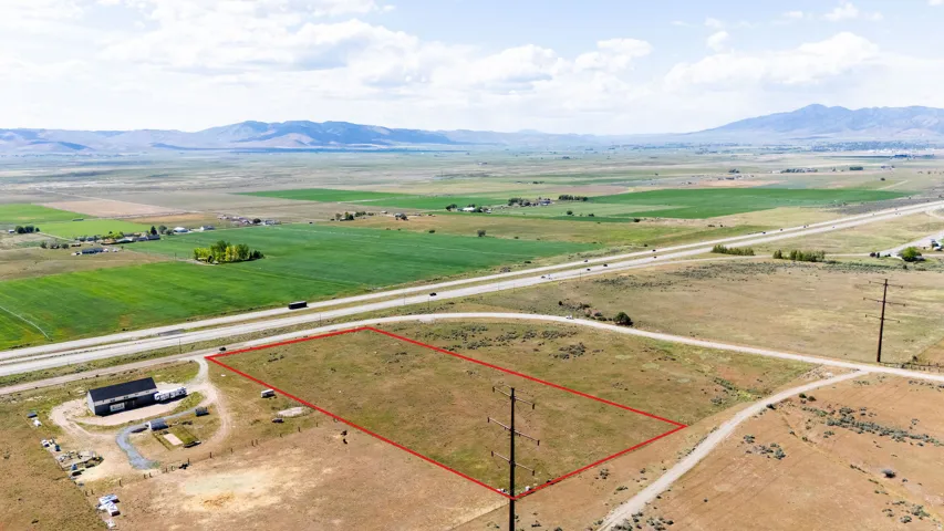 Expansive parcel of undeveloped land, delineated by a red boundary, featuring direct highway frontage