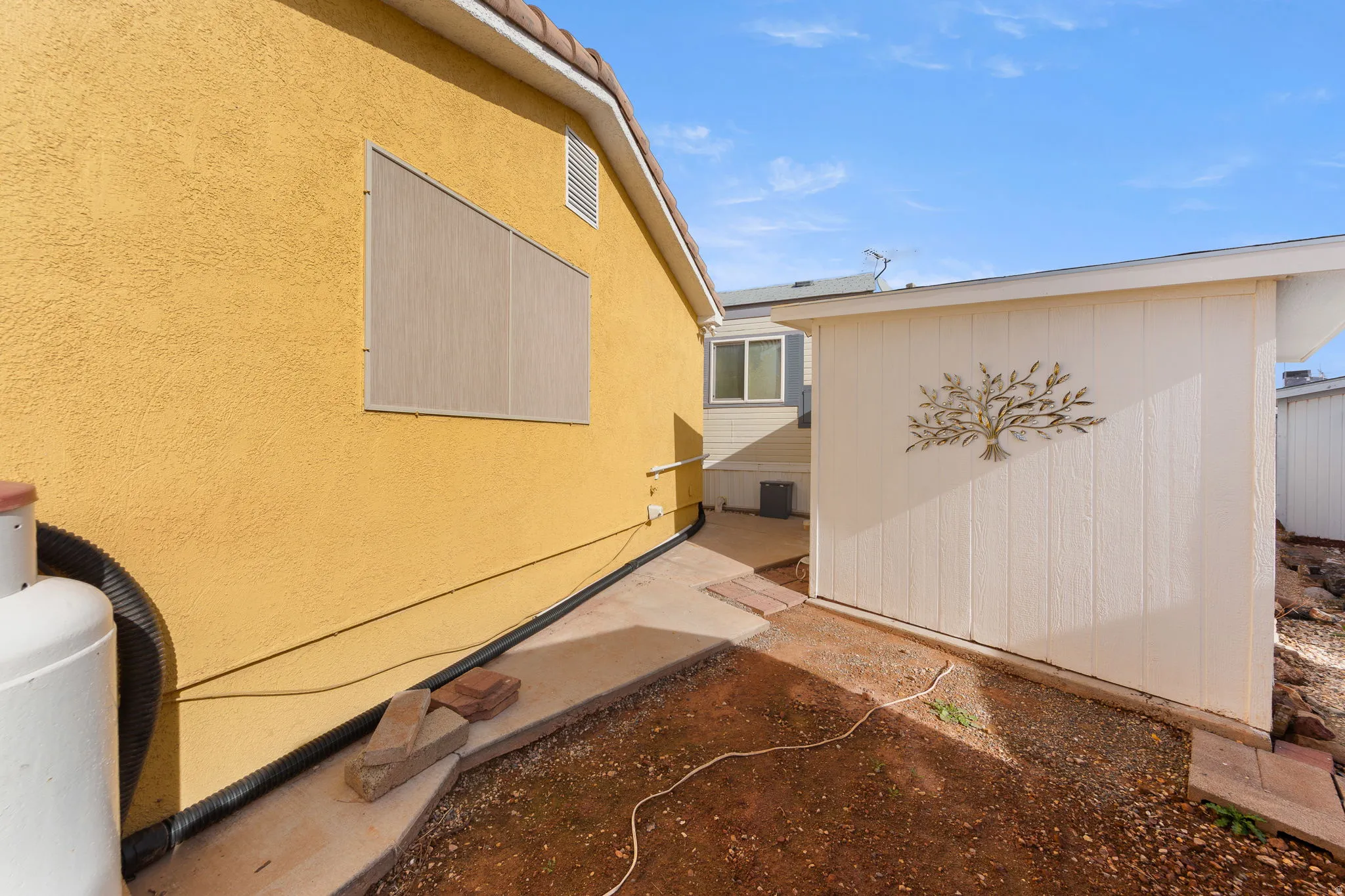 Exterior stucco finish in a warm tone, featuring a terracotta tile roof line