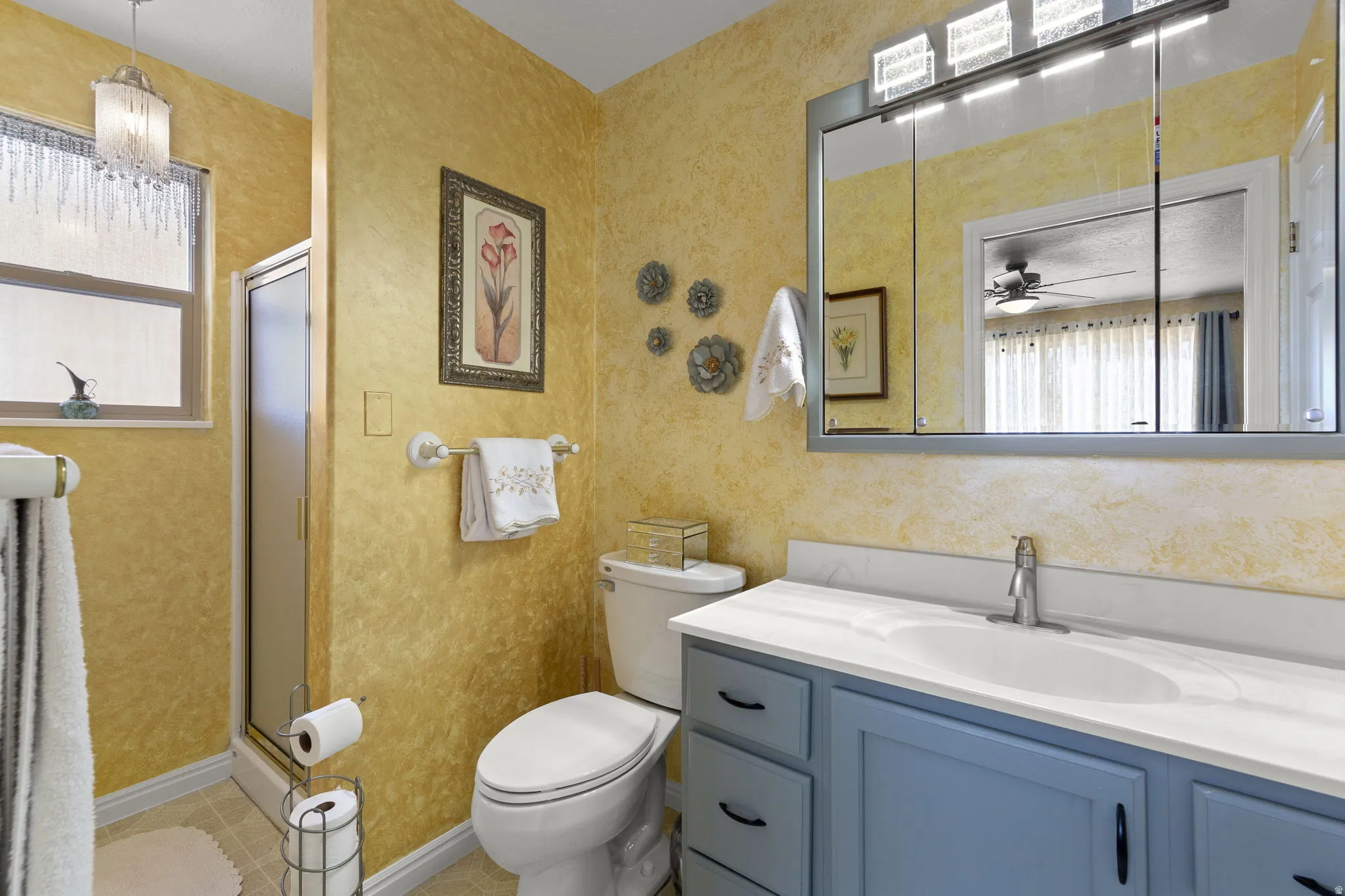 Bathroom featuring a blue vanity with a white countertop, an oval undermount sink, and a chrome faucet
