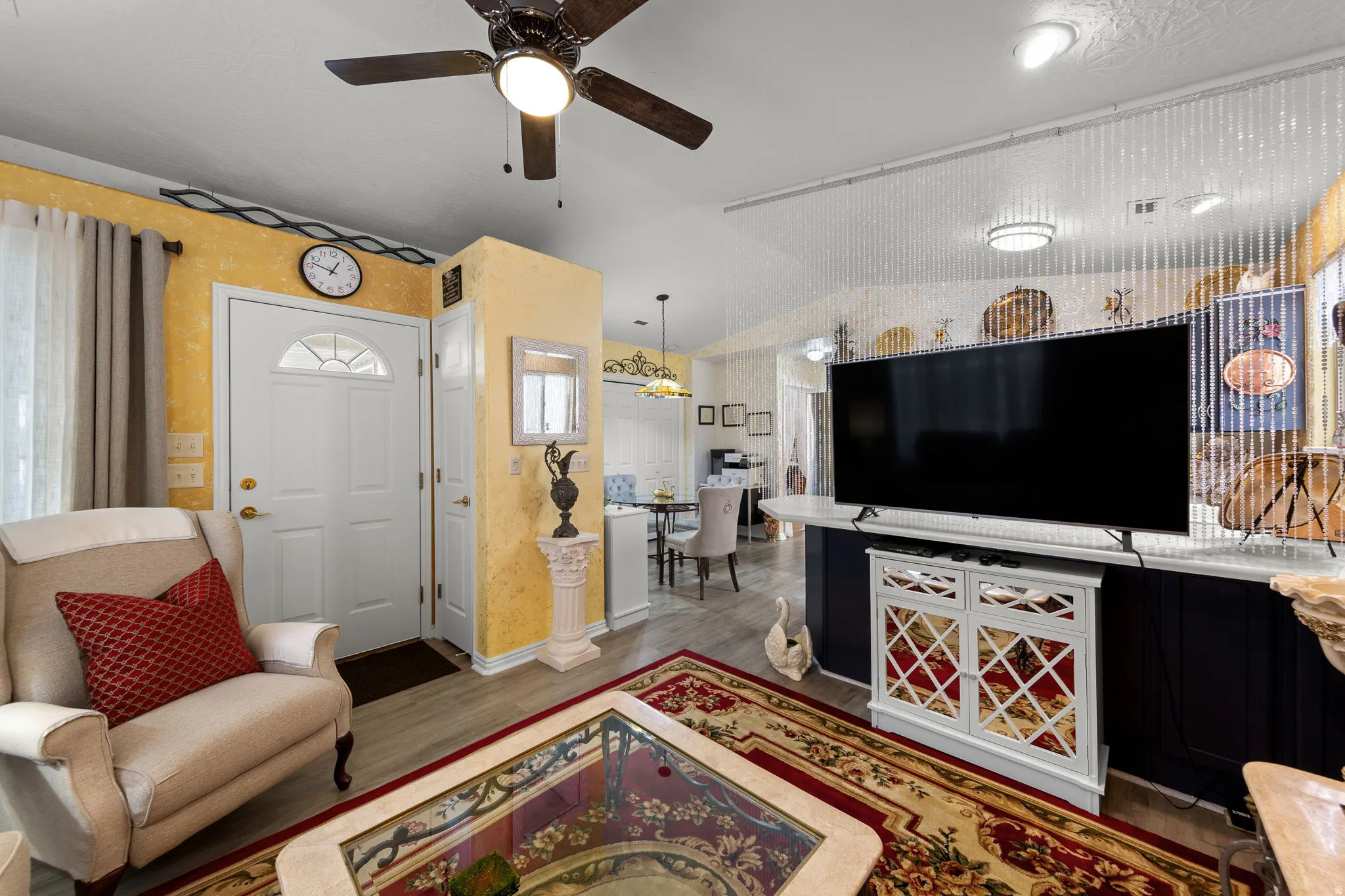 Entryway with a paneled door featuring an arched window, wood-finish flooring, and a ceiling fan with integrated lighting