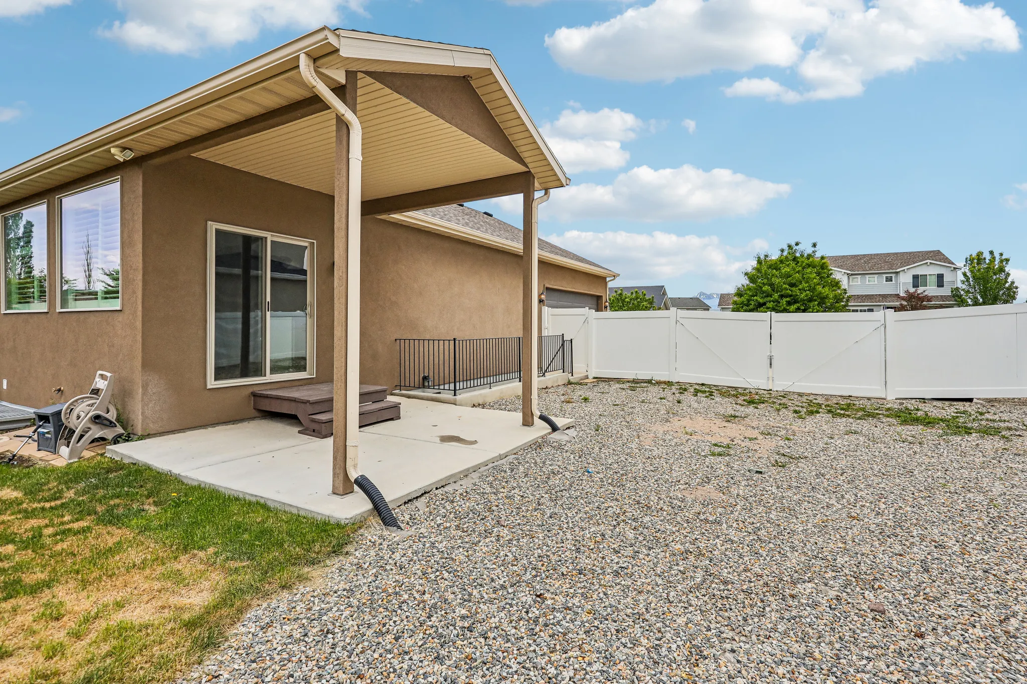 Covered patio with concrete flooring, stucco exterior, and a sliding glass door