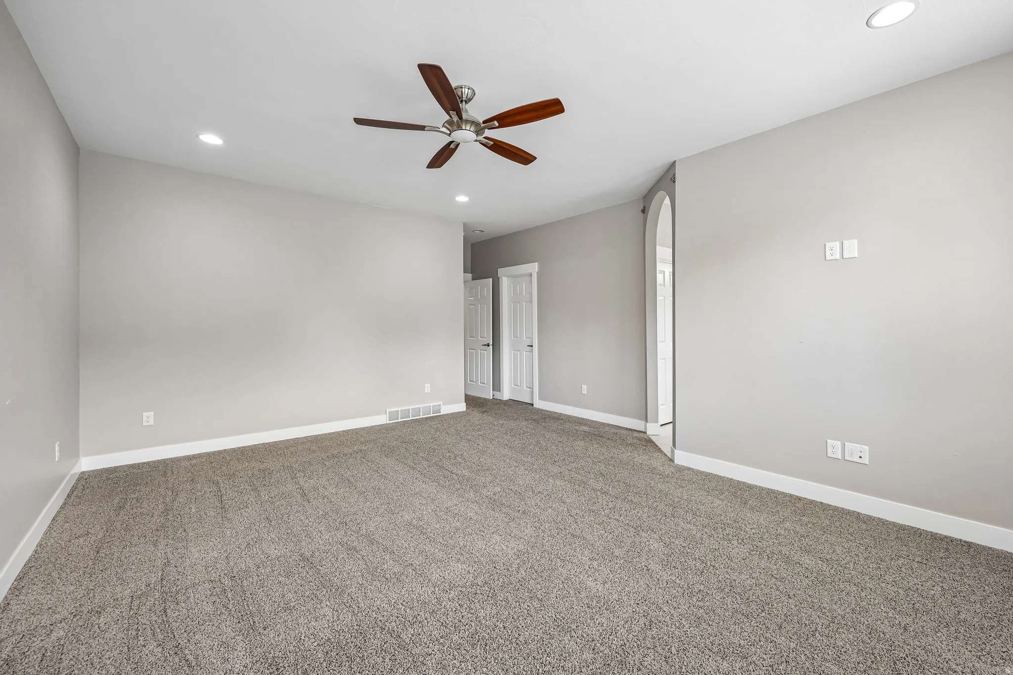 Spacious room featuring neutral carpeting and light gray wall paint