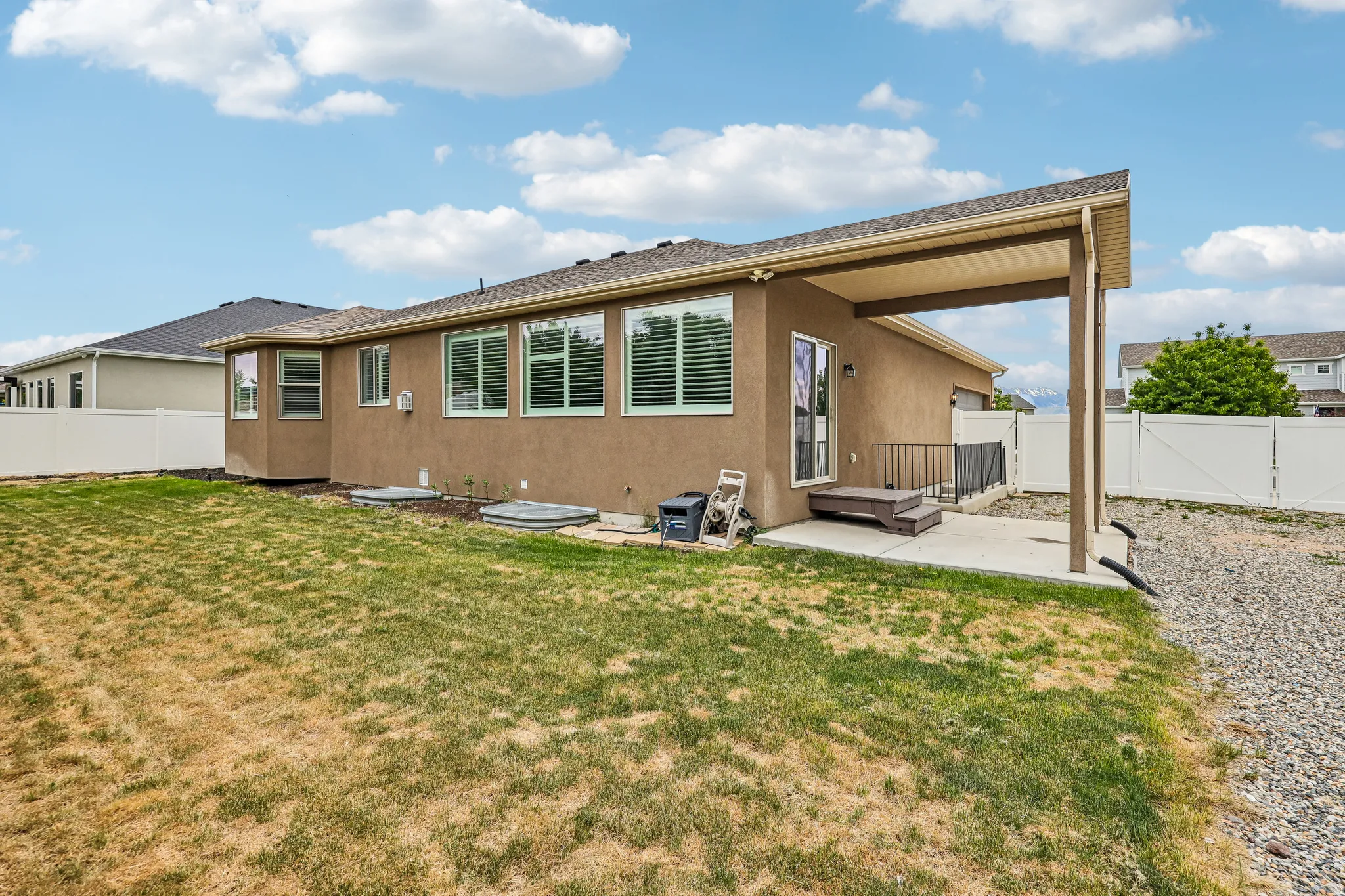 Rear exterior featuring an expansive yard and covered patio