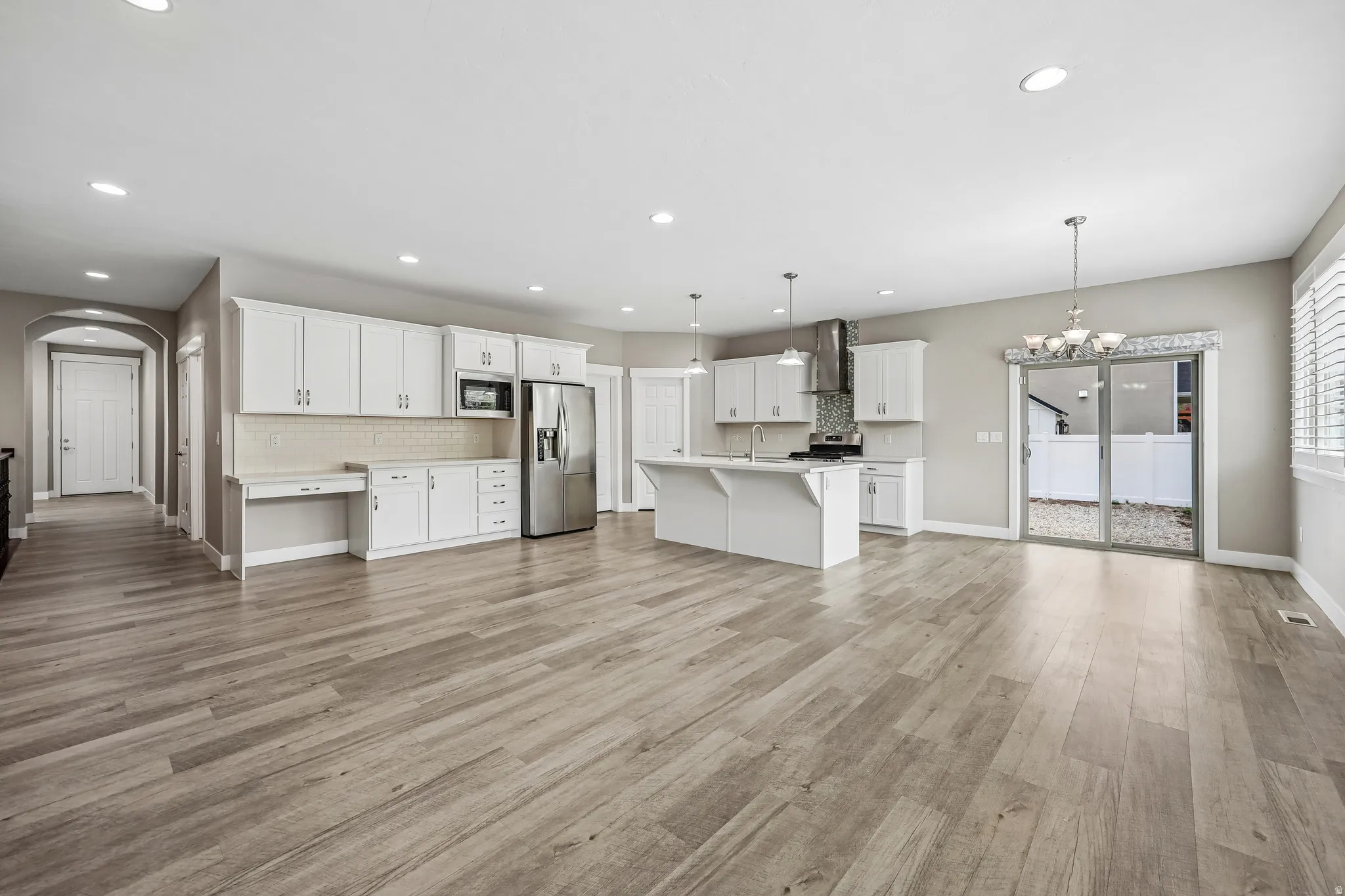 Open-concept living area featuring wood-finish flooring, recessed lighting, and a neutral color palette