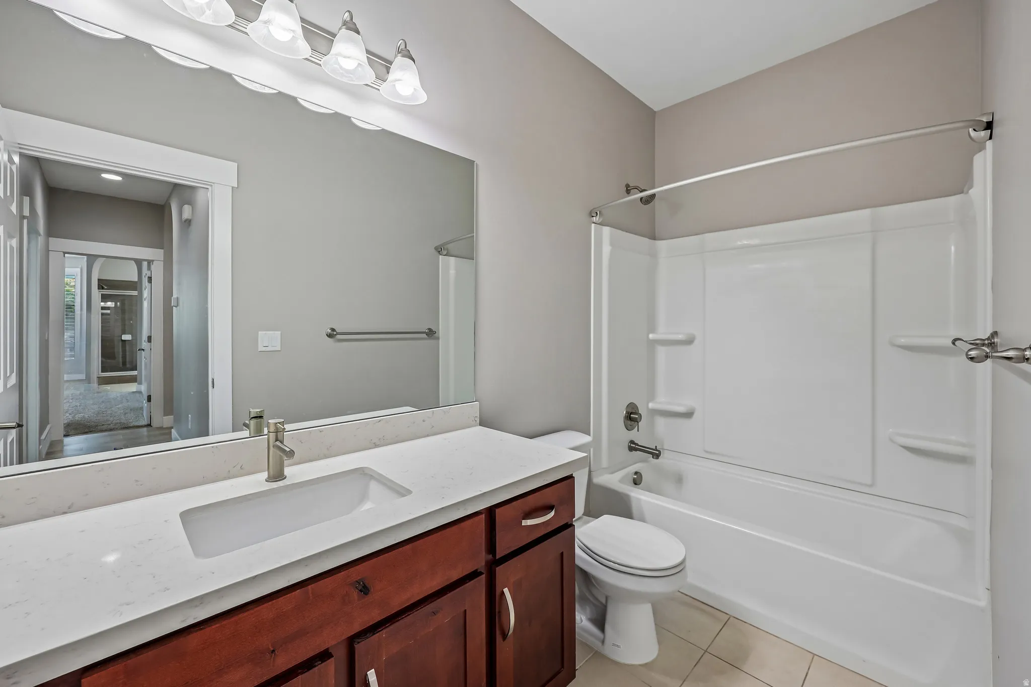 Bathroom featuring a white integrated sink, a light-toned countertop, and a wood-finish vanity with storage