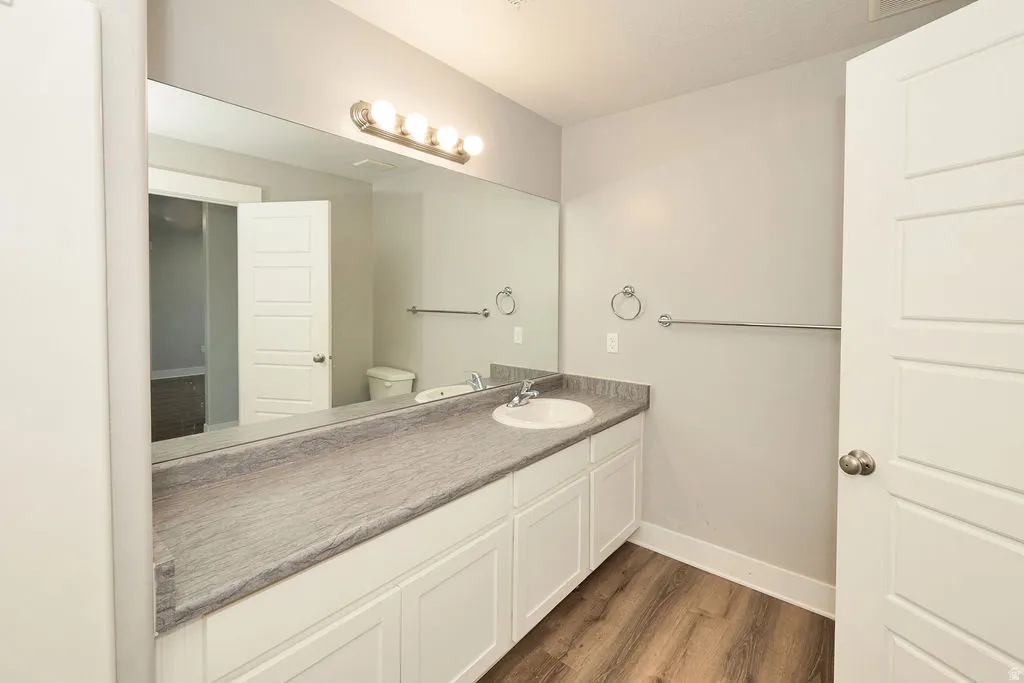 Bathroom featuring a long vanity with a single basin sink and a stone-look countertop