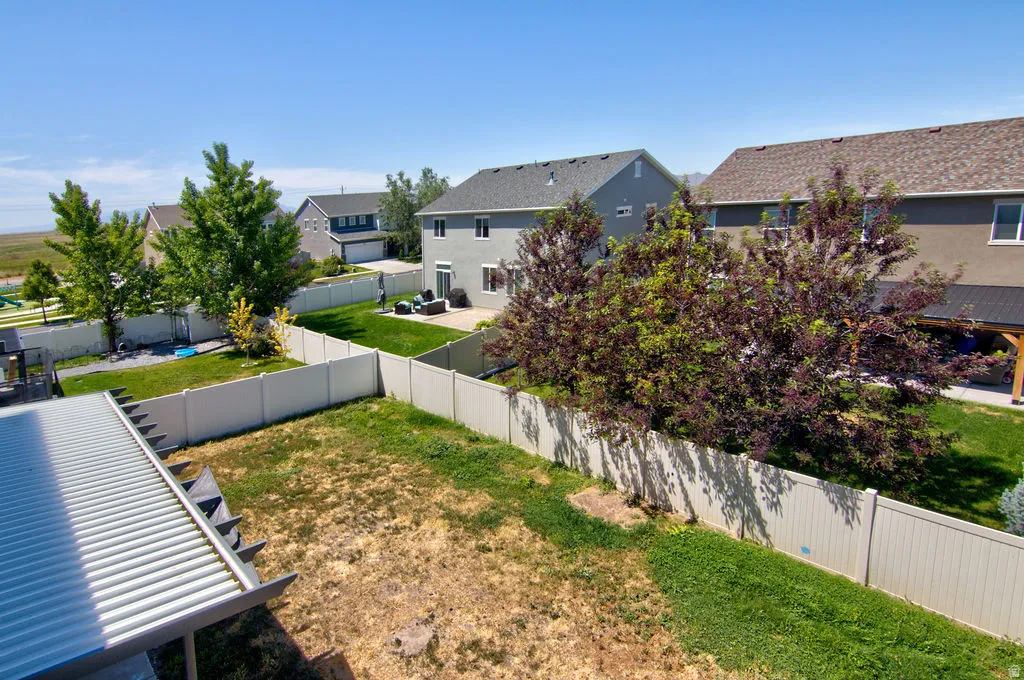 Vinyl privacy fencing enclosing a spacious backyard with mature trees and a manicured lawn