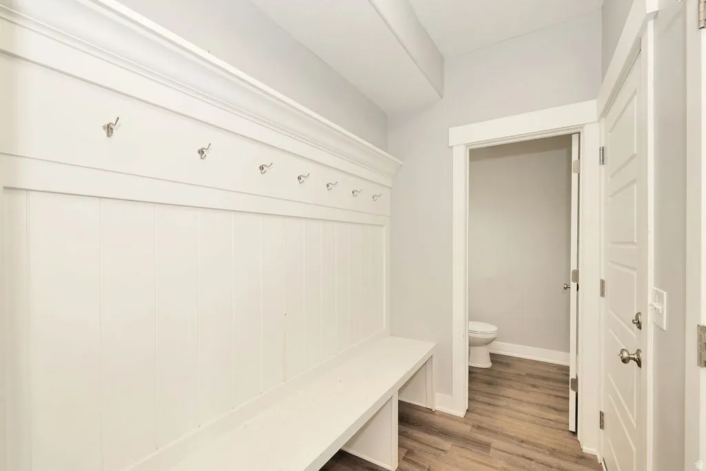 Built-in mudroom bench with coat hooks and beadboard detailing