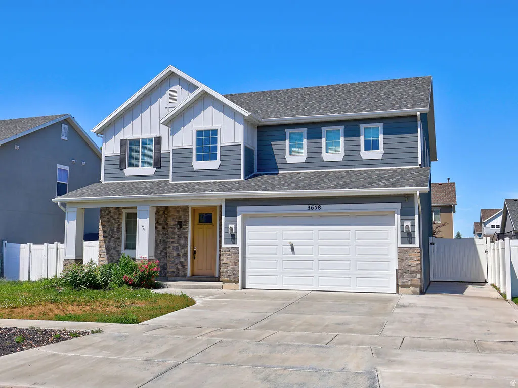 Two-story residence featuring a combination of horizontal siding, vertical siding, and stone accents