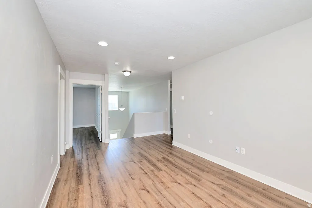 Open living area featuring wood-finish flooring, recessed lighting, and a neutral color palette