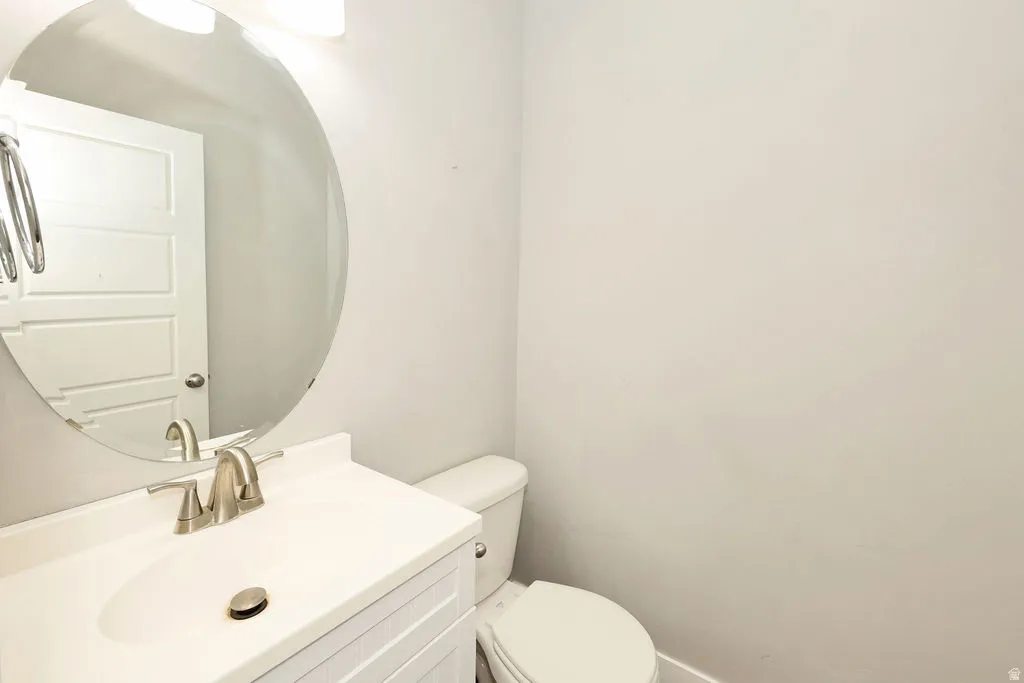 Bathroom vanity featuring a white cabinet with horizontal paneling, an integrated white sink, and a brushed nickel faucet