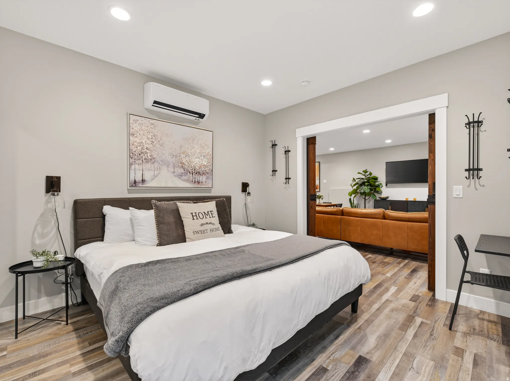 Bedroom featuring wood-finish flooring, recessed lighting, and a wall-mounted air conditioning unit