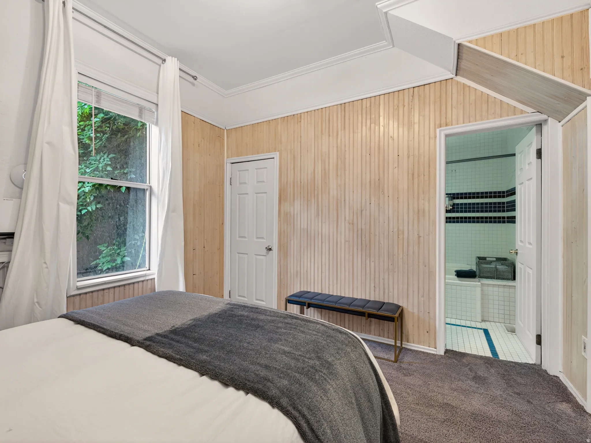 Carpeted room with vertical plank wood-finish wall paneling and crown molding