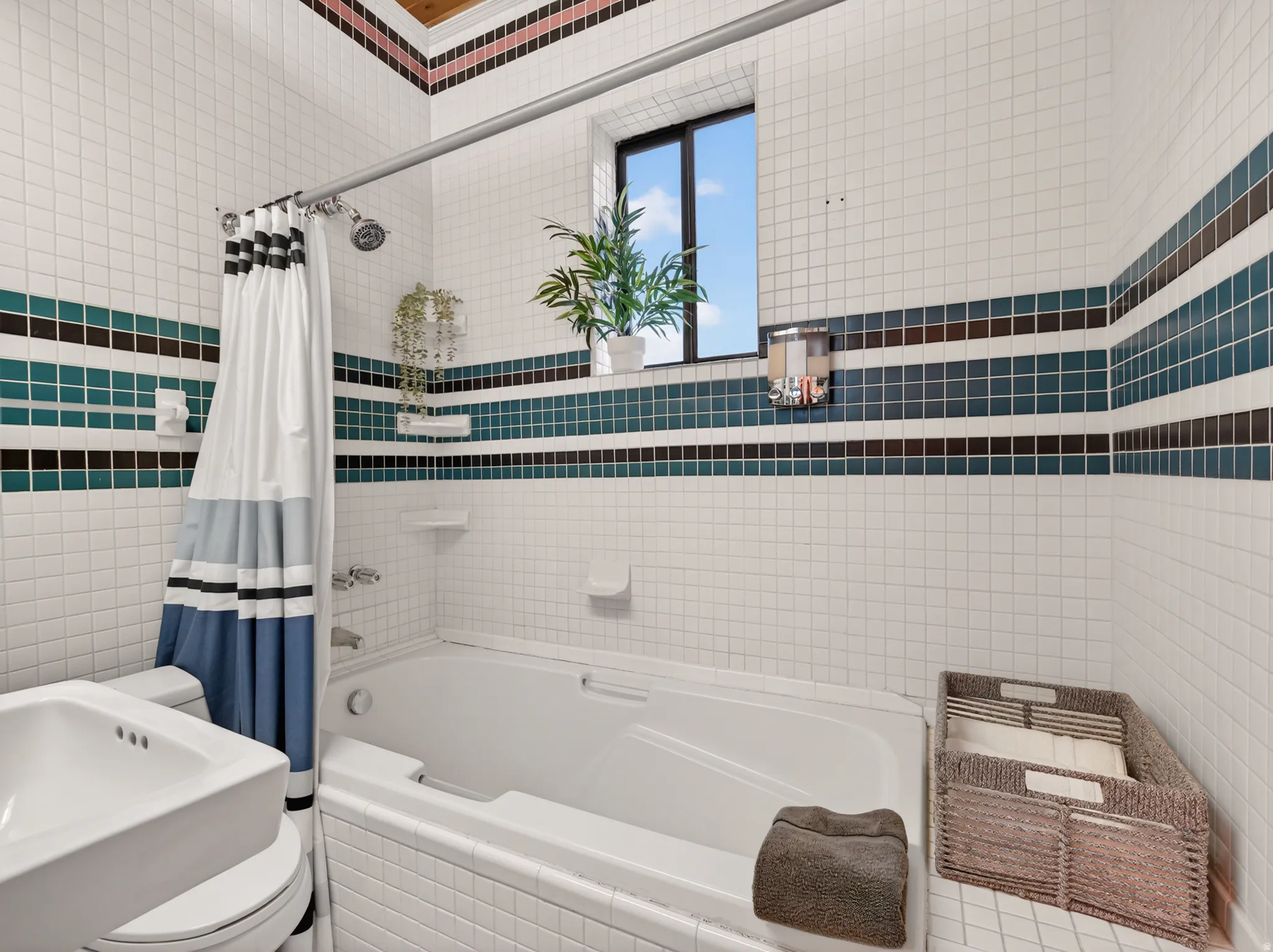 Bathroom featuring a tiled shower and soaking tub combination with an overhead window, white tile walls, and decorative accent bands